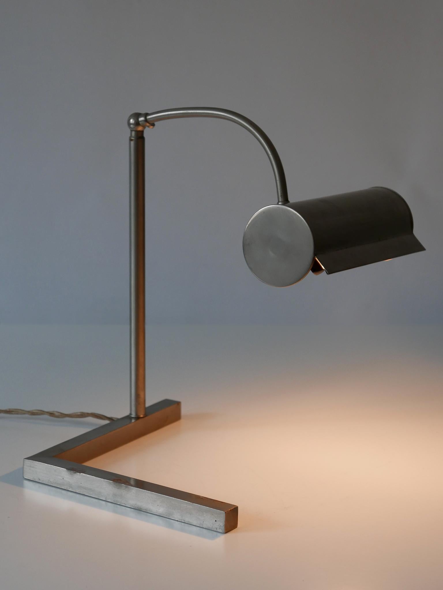 Exceptional, minimalistic Bauhaus / Modernist table lamp or desk light with adjustable height and shade. Designed probably by Jacobus Johannes Pieter Oud for W. H. Gispen, 1920s, Rotterdam. 

Executed in nickel-plated brass, the table lamp needs 1