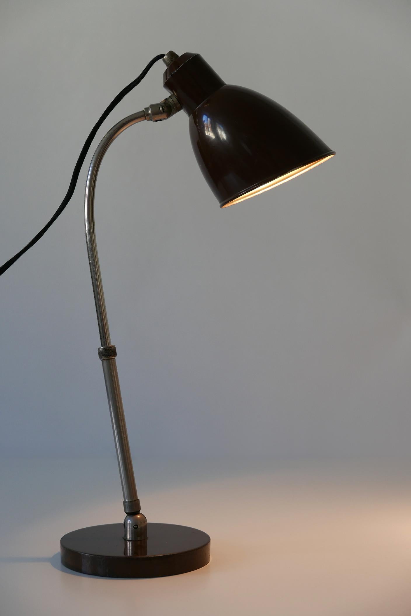 Extremely rare German Bauhaus table lamp 'Piccolo' with adjustable height, arm and shade. Designed by Christian Dell for Bünte & Remmler (BuR), 1930s, Germany. 
Makers mark beneath the base: Piccolo BuR 3244.

Executed in dark brown enameled and