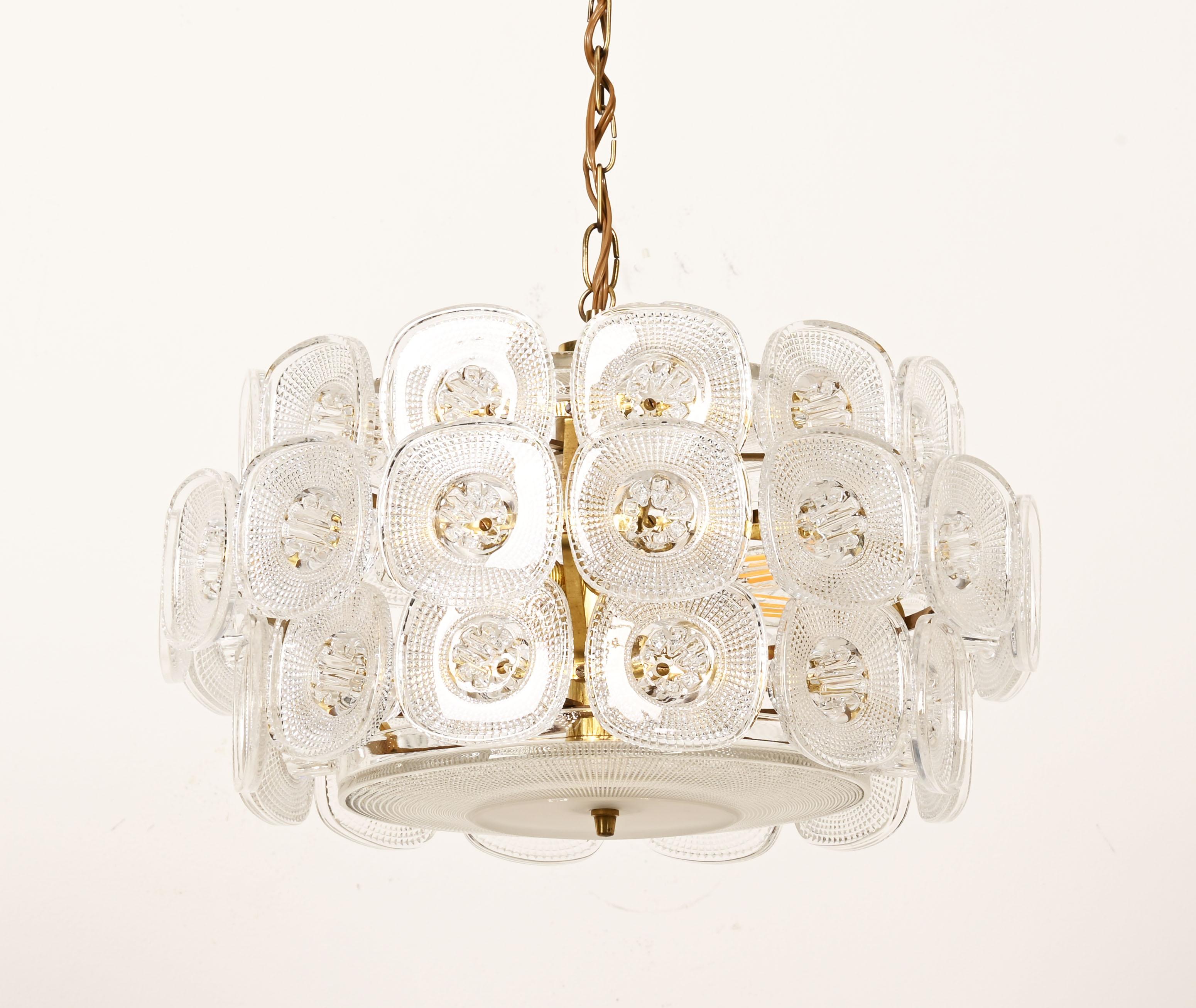 Very rare chnadelier, brass construction, fitted with six E14 sockets. The decor of ornament in pressed glass, designed by Kjell Blomberg for Gullaskrufs glasbruk in Sweden in the 1960s. Height the chandelier without the chain is 30cm.
   