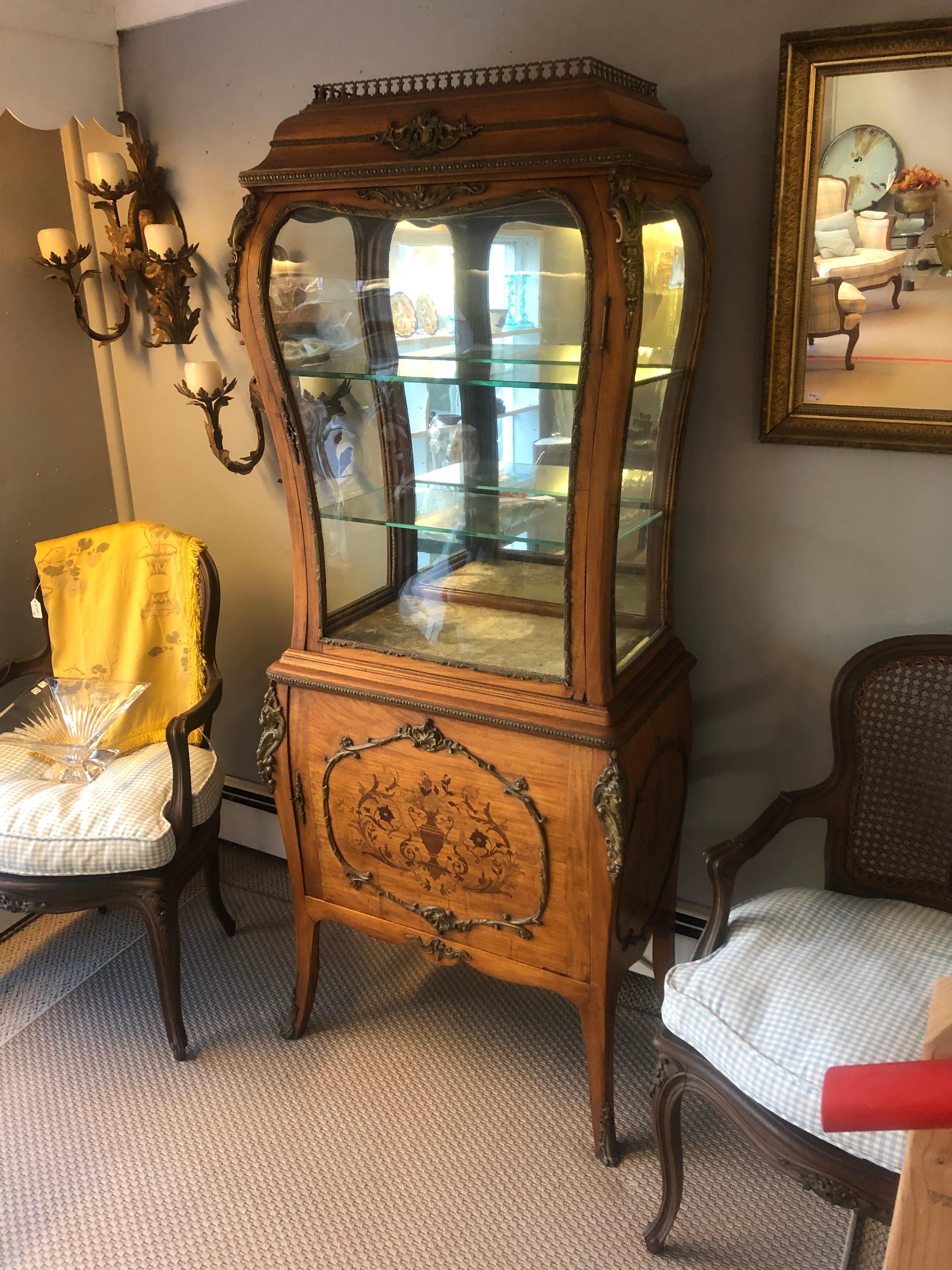 Magnificent and rare 19th century Edwardian inlaid bombe shaped curio cabinet vitrine with sensuous silhouette. Top has original glass on 3 sides to allow elegant display space with two glass shelves, velvet lined bottom and mirrored back. Bottom