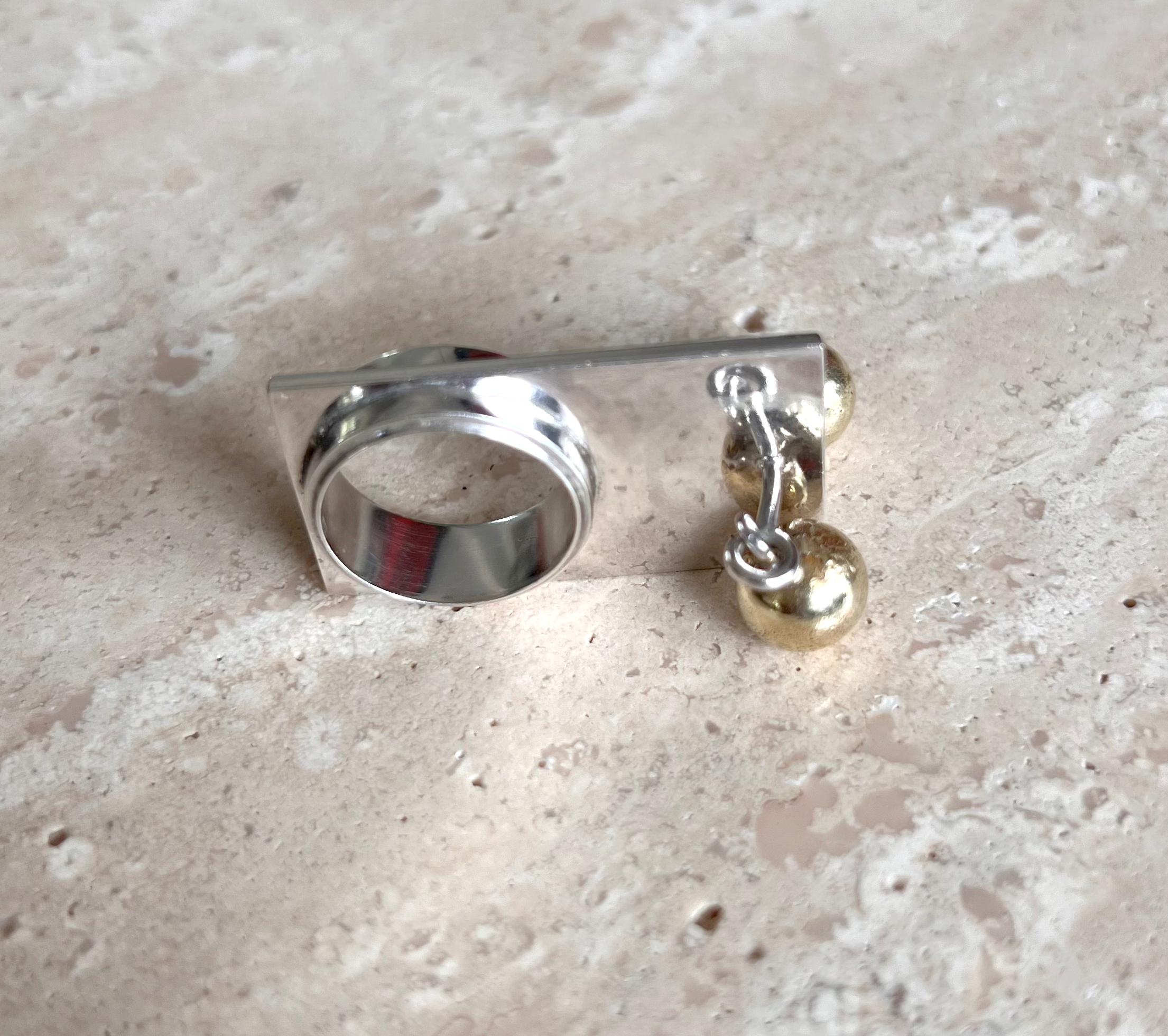 Rare bague en argent sterling avec un léger lavis d'or sur les boules cinétiques à bascule. Créé par le danois Bent Exner dans les années 1960.  Taille 5.5 et en très bon état.