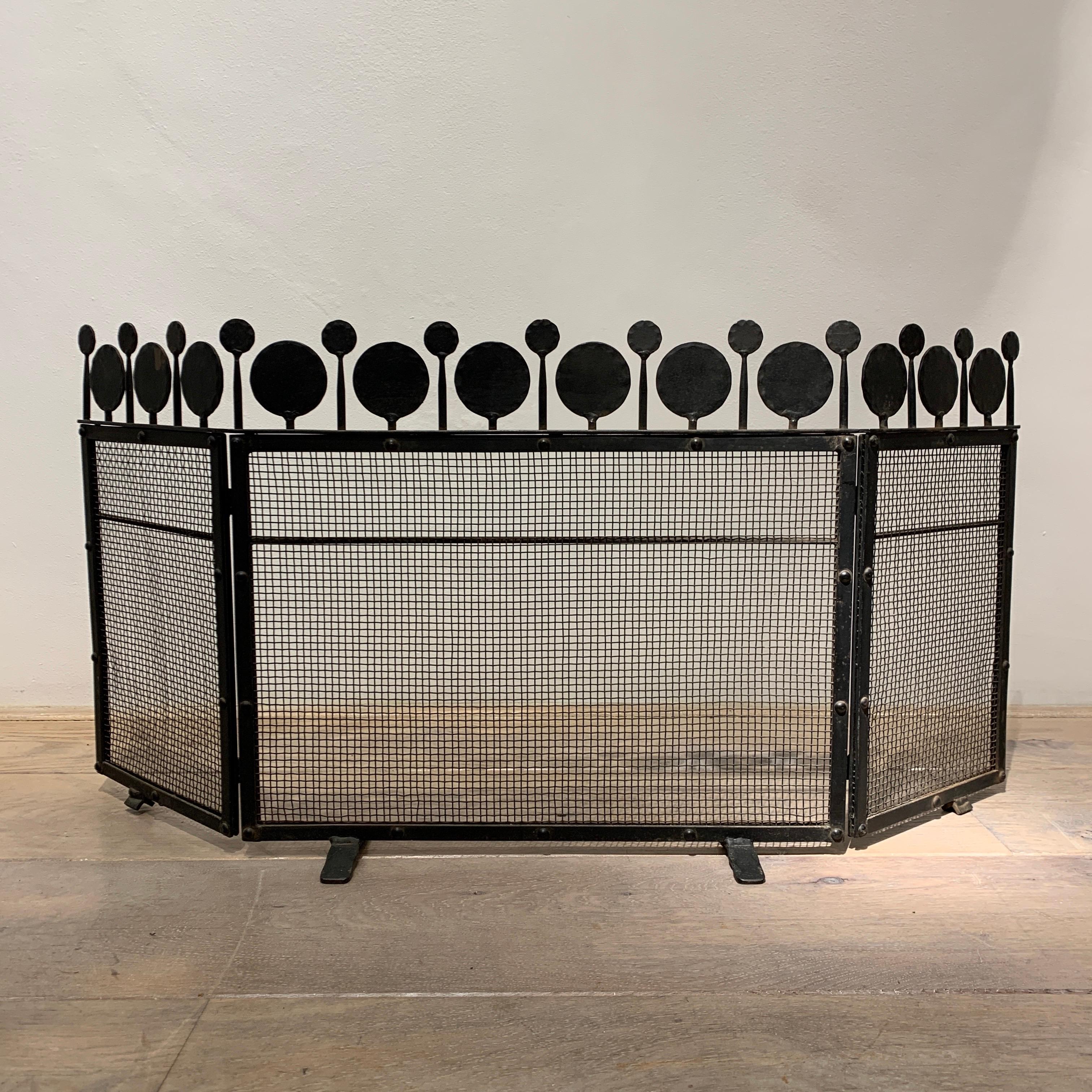 This fire screen is a work of art in itself. It is very simple and elegant design. The top is decorated by a forest of small tree shape like forms. They are hammered on the outside to give some contrast. It is a highly decorative piece by a great