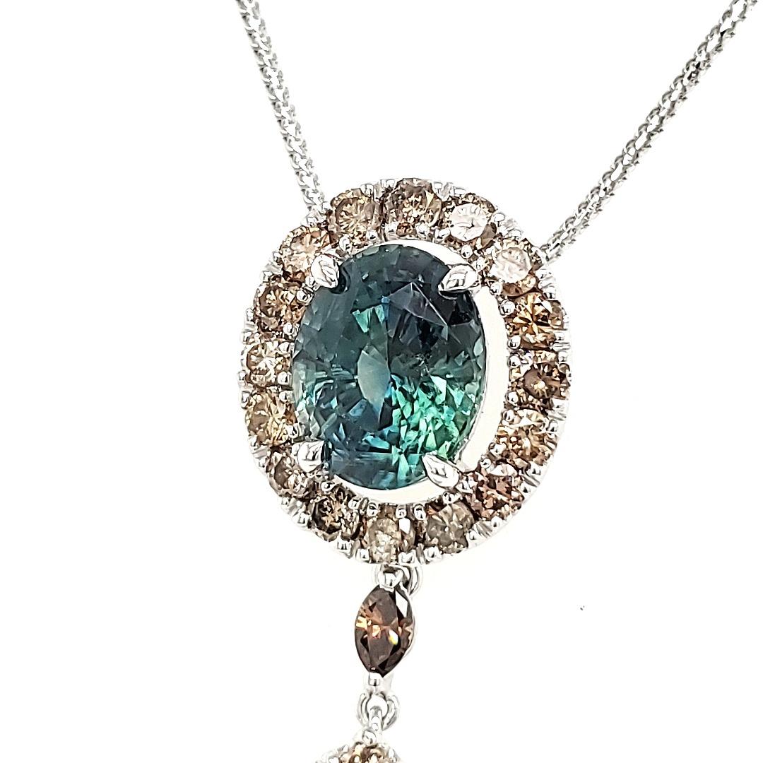 Rare Bi-colored Blue - Green Sapphire pendant with pear and round diamonds. 

Seldom, if  ever, did you see a two colored sapphire and this has blue as well as green to produce a cyan color that is exceptionally rare.
It forms the centre of this