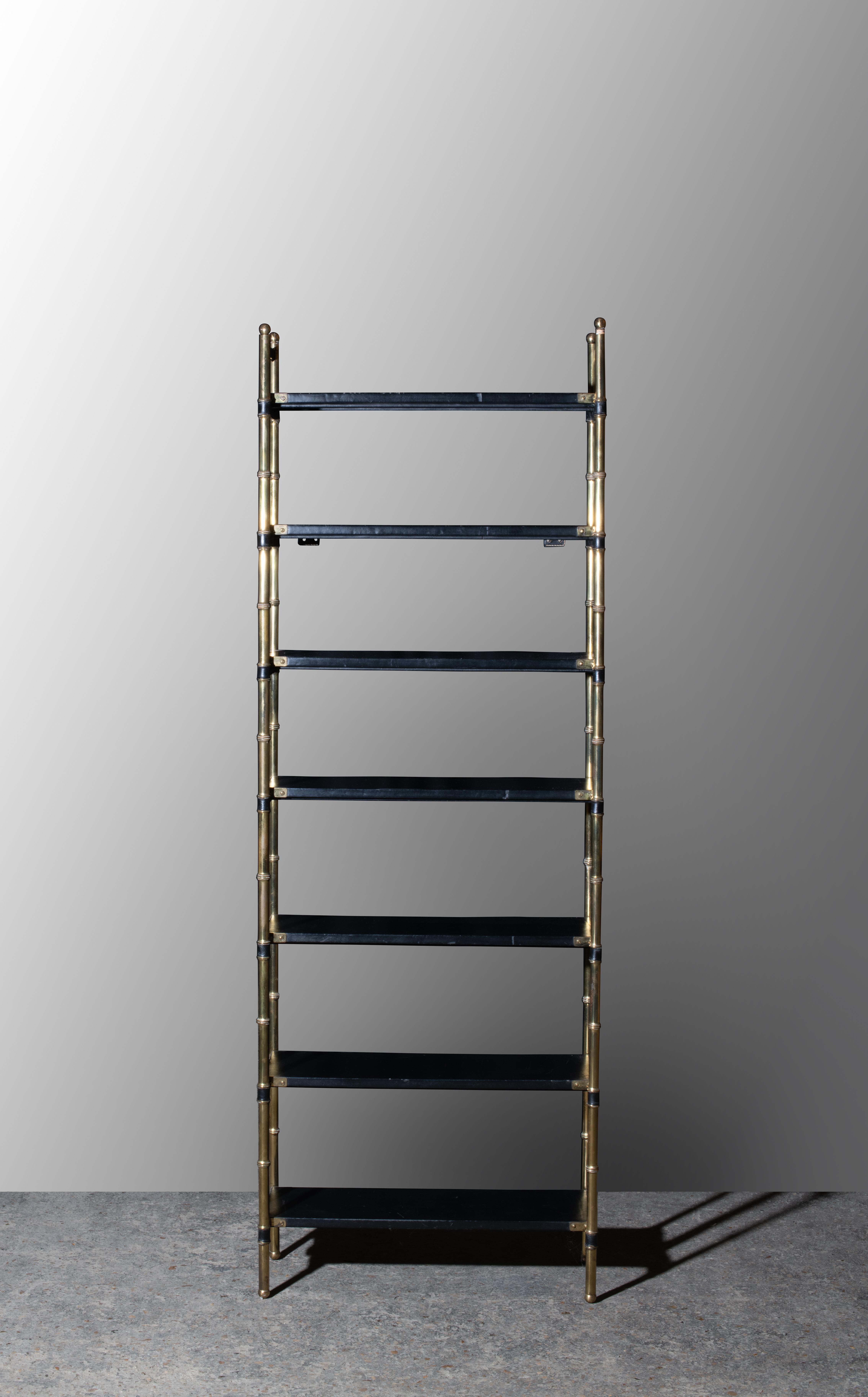 Biblioteca con struttura in laiton dorato che imita il bambù e che racchiude delle etichette sovrapposte interamente guadagnate in pelle nera. 
Jacques Adnet è un architetto décorateur e designer francese del XX secolo. È all'età di sei anni che