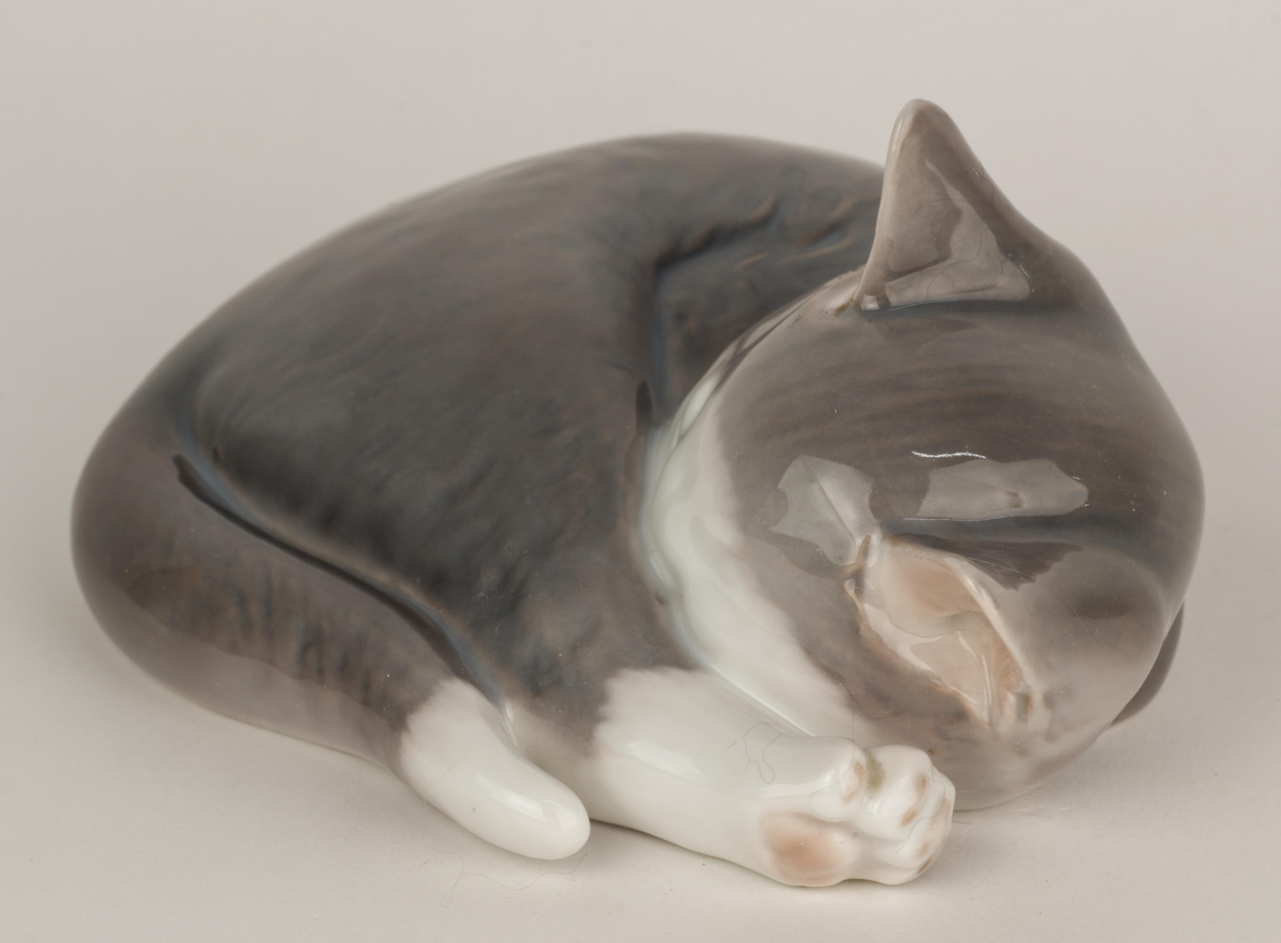  Charming vintage figurine of a sleeping grey cat was made by Bing & Grøndahl in 1950s. Highly detailed porcelain figurine was hand-decorated with extra attention to cat's face, ears, and fur.

The piece is marked with green factory stamps that date