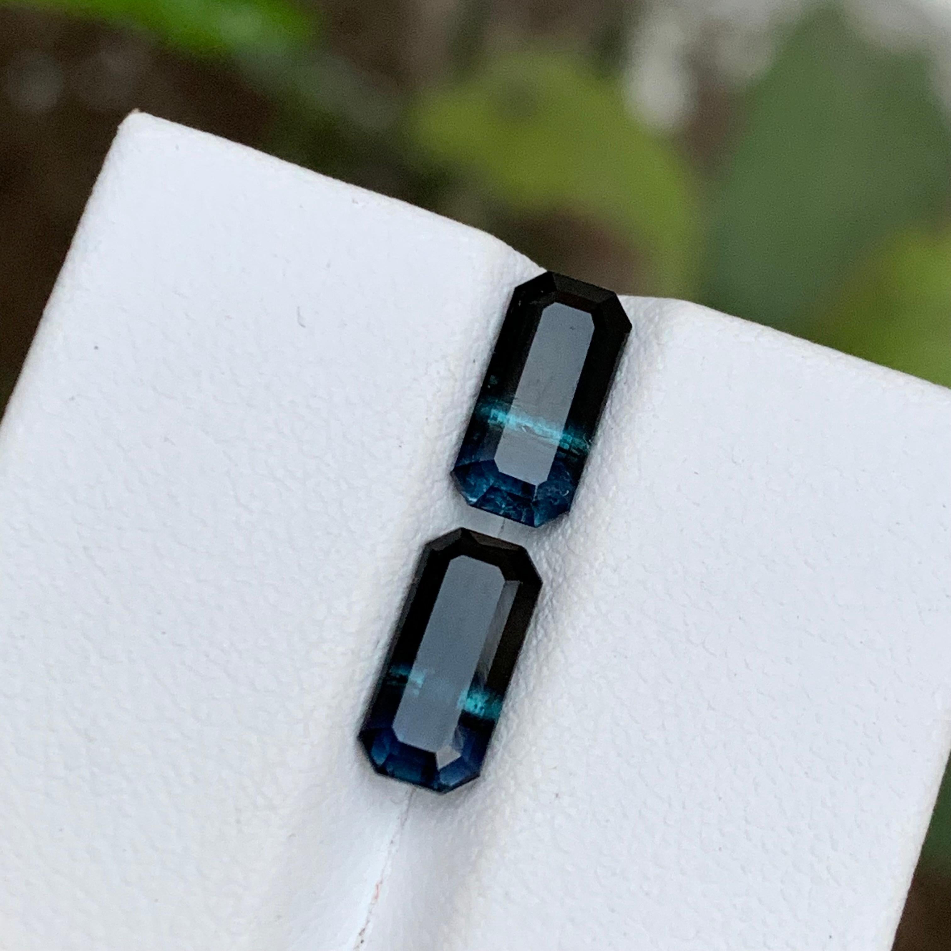 GEMSTONE TYPE: Tourmaline
PIECE(S): Pair
WEIGHT: 3.10 Carats
SHAPE: Emerald
SIZE (MM): 
1.50 Carat: 9.38 x 4.60 x 3.85
1.55 Carat: 9.45 x 4.58 x 3.89
COLOR: Bicolor Black and Blue
CLARITY: Slightly Included
TREATMENT: None
ORIGIN: