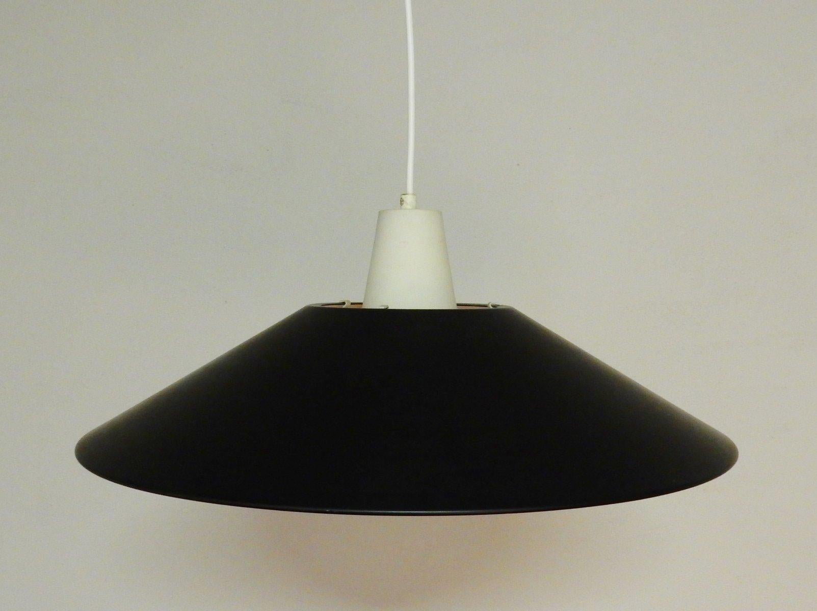Questa lampada a sospensione in lacca bianca e nera è stata disegnata da Per Iversen per Louis Poulsen, in Danimarca, negli anni '60. Fa parte della serie Combi Lamperne / Multi-combination Lamps. Una lampada semplice ma molto bella, in ottime