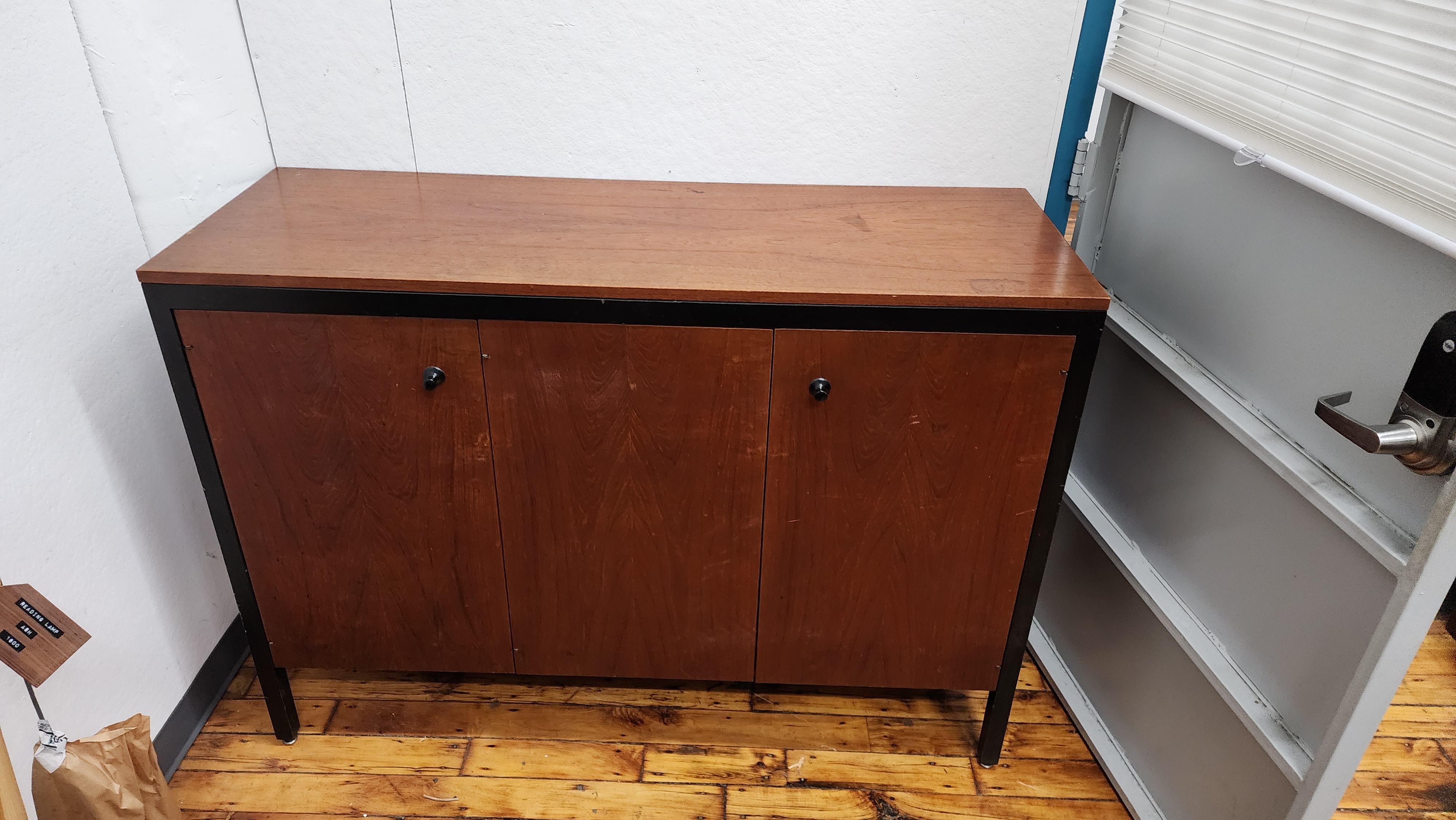 Raro mobile in teak con struttura nera di George Nelson per Herman Miller.  Dispone di 3 ante, all'interno dell'anta sinistra c'è un cassetto e dei ripiani, l'altro lato ha 4 cassetti.  

potrebbe essere utilizzato come credenza,  credenza o in un