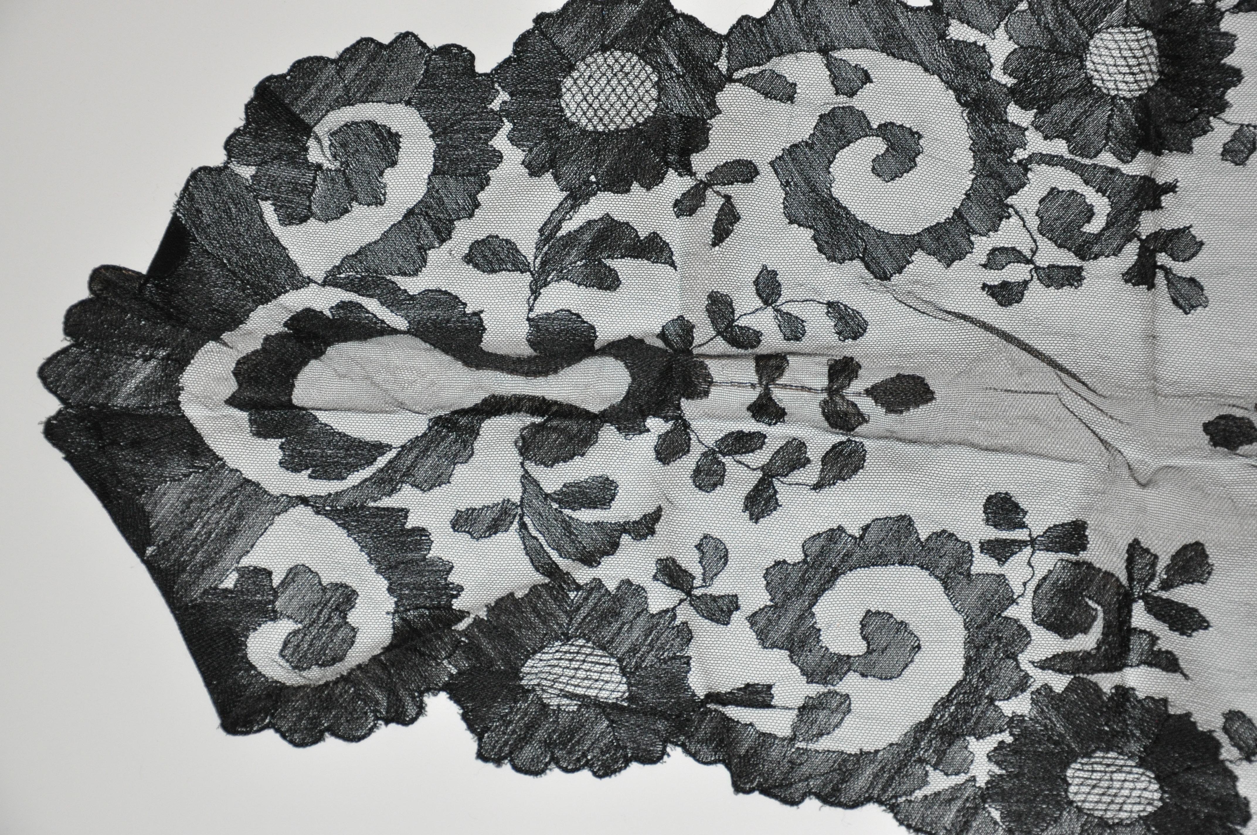        This rare black hand-woven French lace shawl accented with scallop edges, measures 62 inches in length and the width measures  3 1/2 inches to 22 inches. Hand-woven and made in France. 