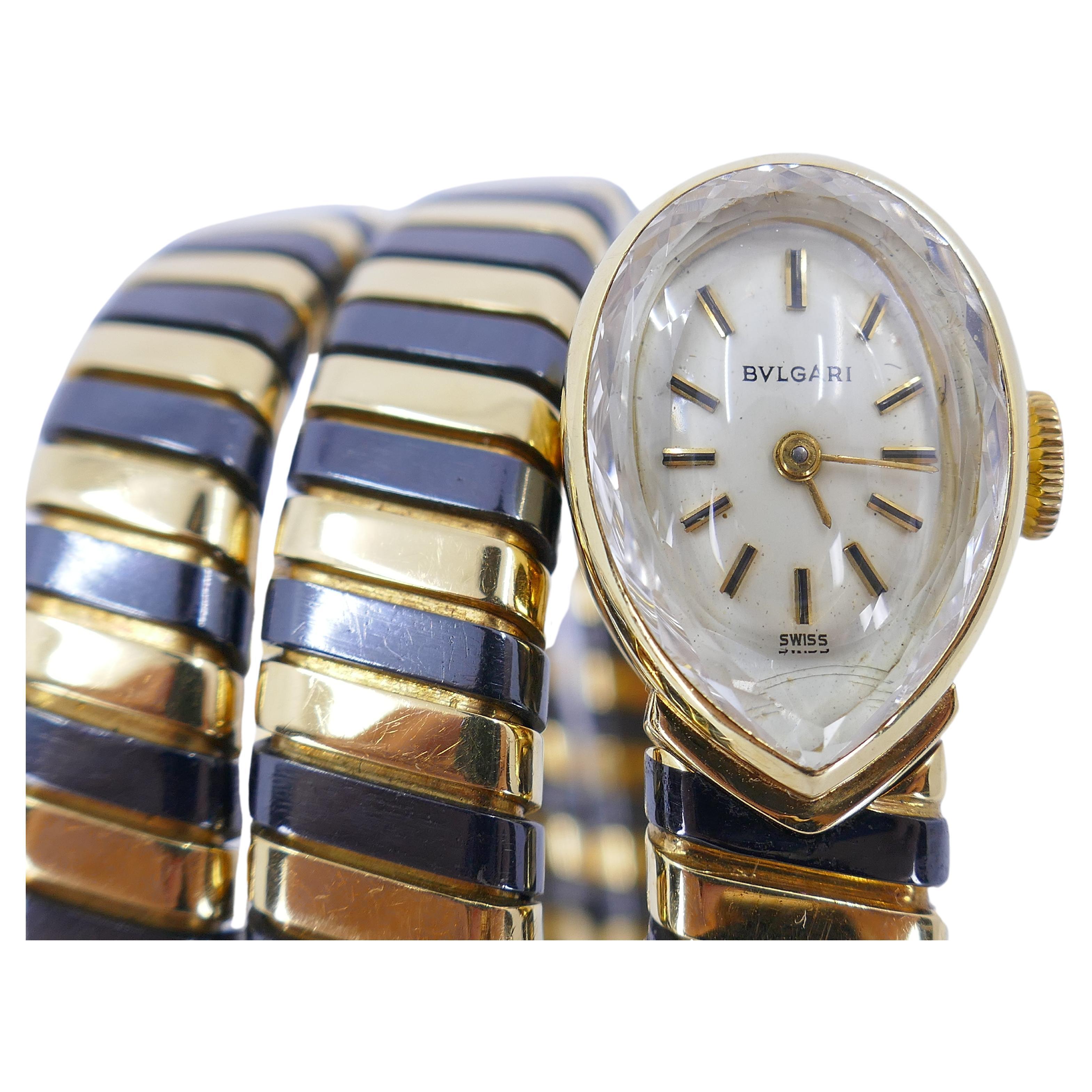 Eine seltene Version der kultigen Bulgari Tubogas-Uhr aus dem  abwechselnd geschwärztes und gelbes 18-karätiges Gold. Das Gehäuse ist birnenförmig, mit weißem Zifferblatt, goldenen Stabindexen und schwarzer Emaille verziert. 
Die Uhr ist elegant,