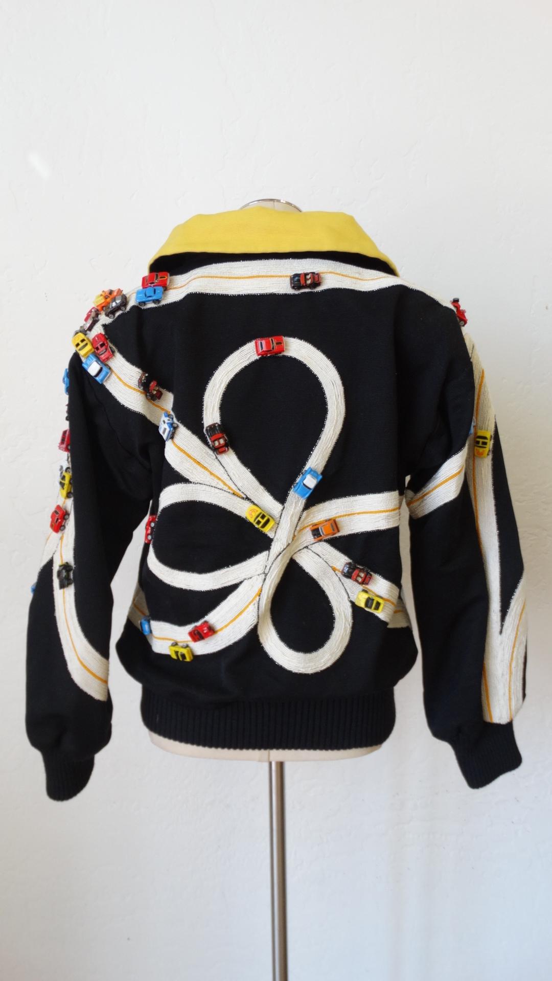 The Most Amazing Jacket Is here! Circa 1990s, this Bob Mackie oversized jacket features a winding street with a variety of miniature toy cars placed throughout. The sleeves and hem are ribbed cotton for a snug fit. The lining is a vibrant yellow and