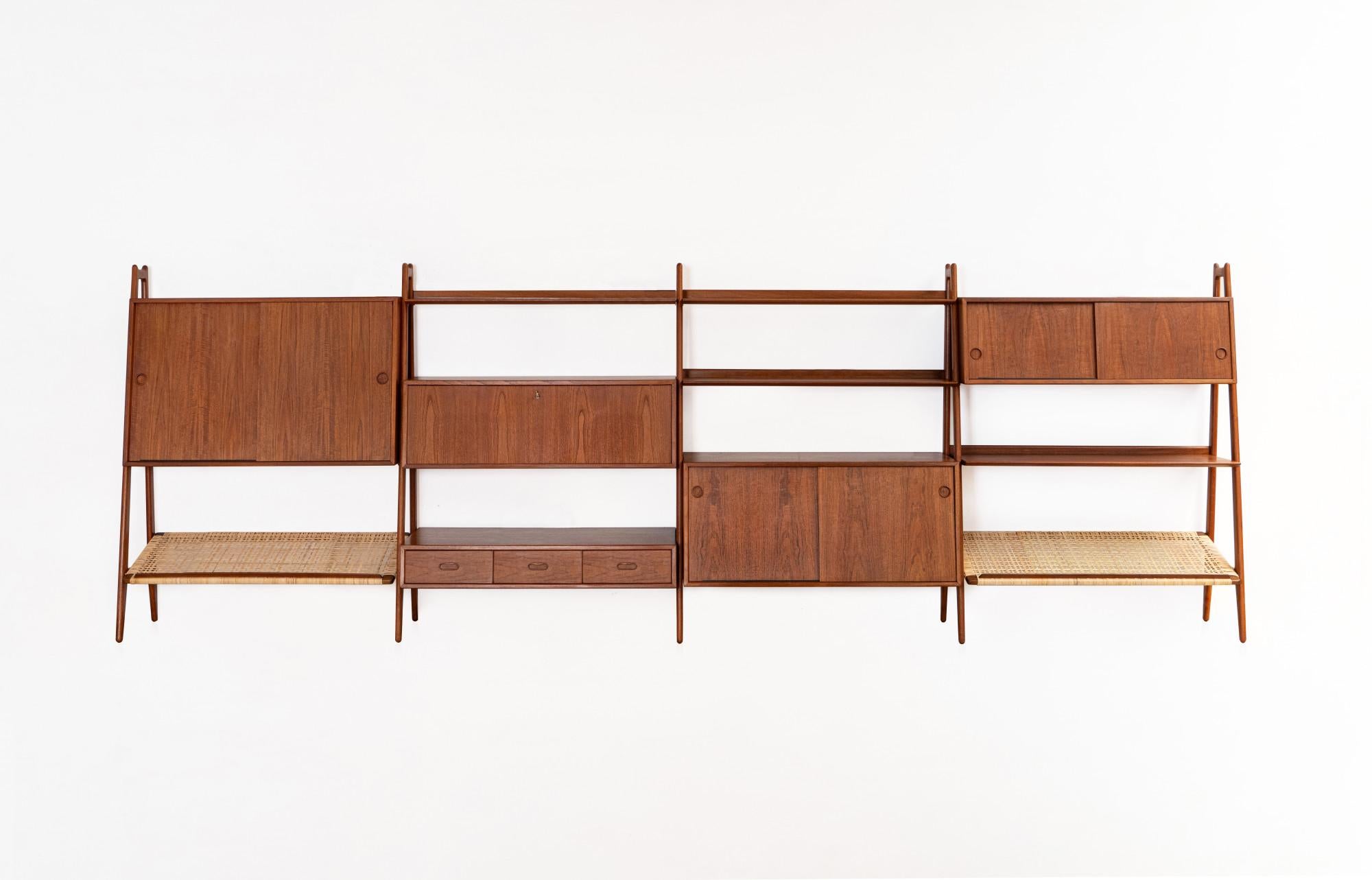 This rarely available bookcase, a true masterpiece, was designed by Arne Vodder and Anton Borg for Vamo Møbelfabrik in the 1950s

It includes five cabinet elements, four bookshelves and two rattan magazine shelves. The rattan wickerwork has been