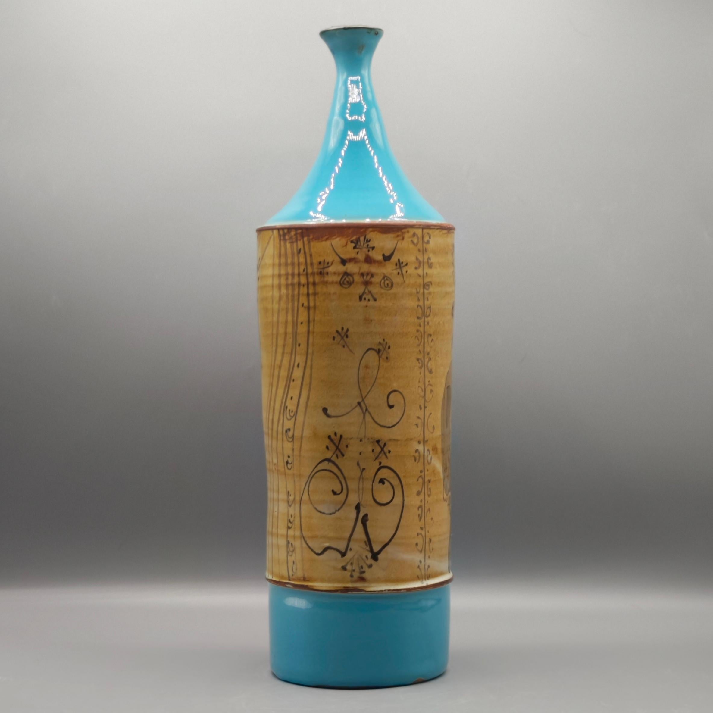 A forma di bottiglia alta  vaso in ceramica. 
 Il corpo della bottiglia rappresenta 2 personaggi, uno su ogni faccia. 
 Il colletto e la base sono smaltati in un colore blu brillante.
Gilbert Portanier. 1926 /2023
Vallauris AM circa 1970 
firmato
