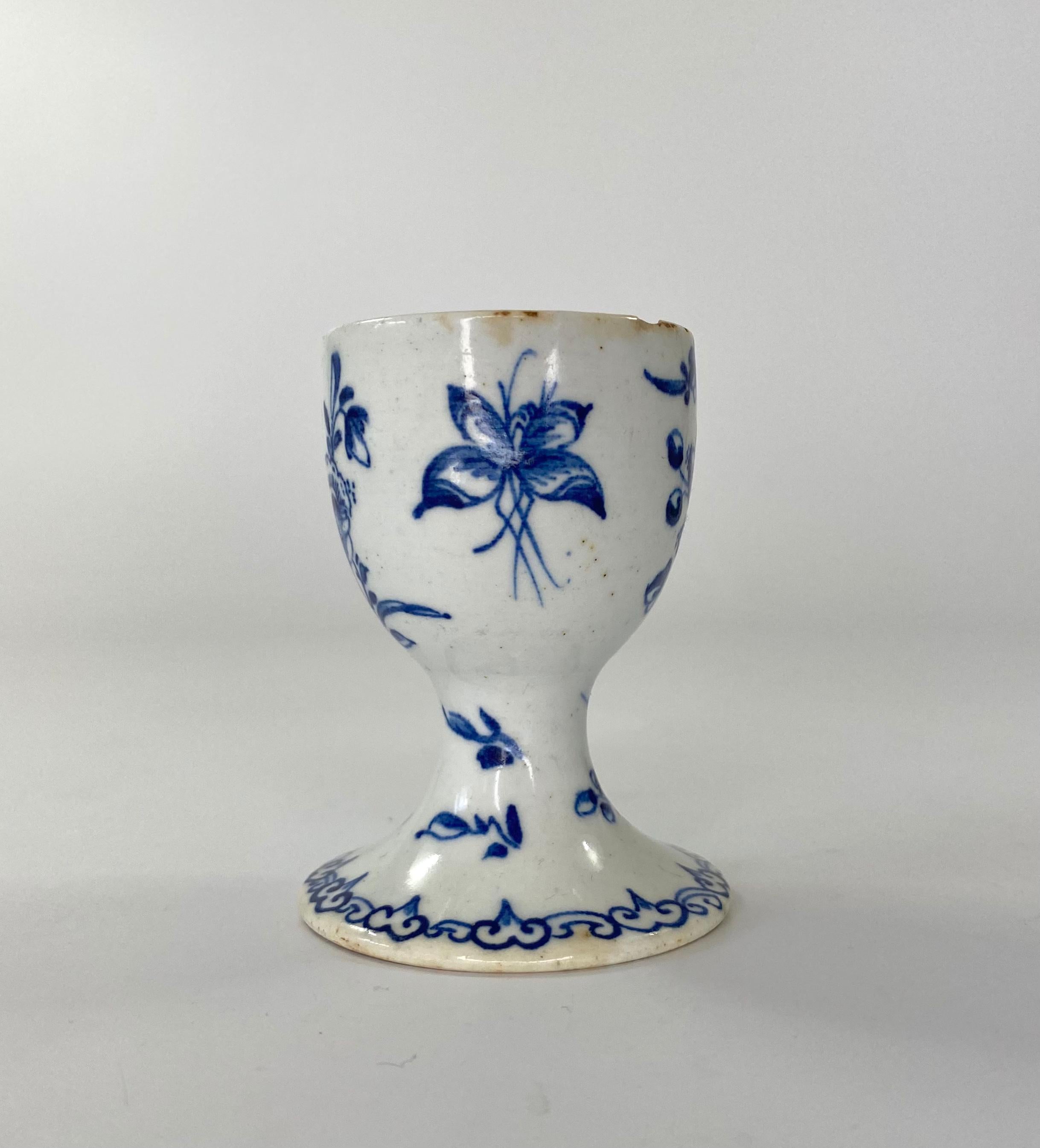 Rare bow porcelain egg cup, c. 1760. Hand painted in underglaze blue, with sprays of flowers, and moths.
The interior, with a cell diaper motif to the rim.
Medium: Porcelain.
Height: 7 cm, 2 3/4”.
Width: 5.3 cm, 2 1/8”.
Condition: Two chips to