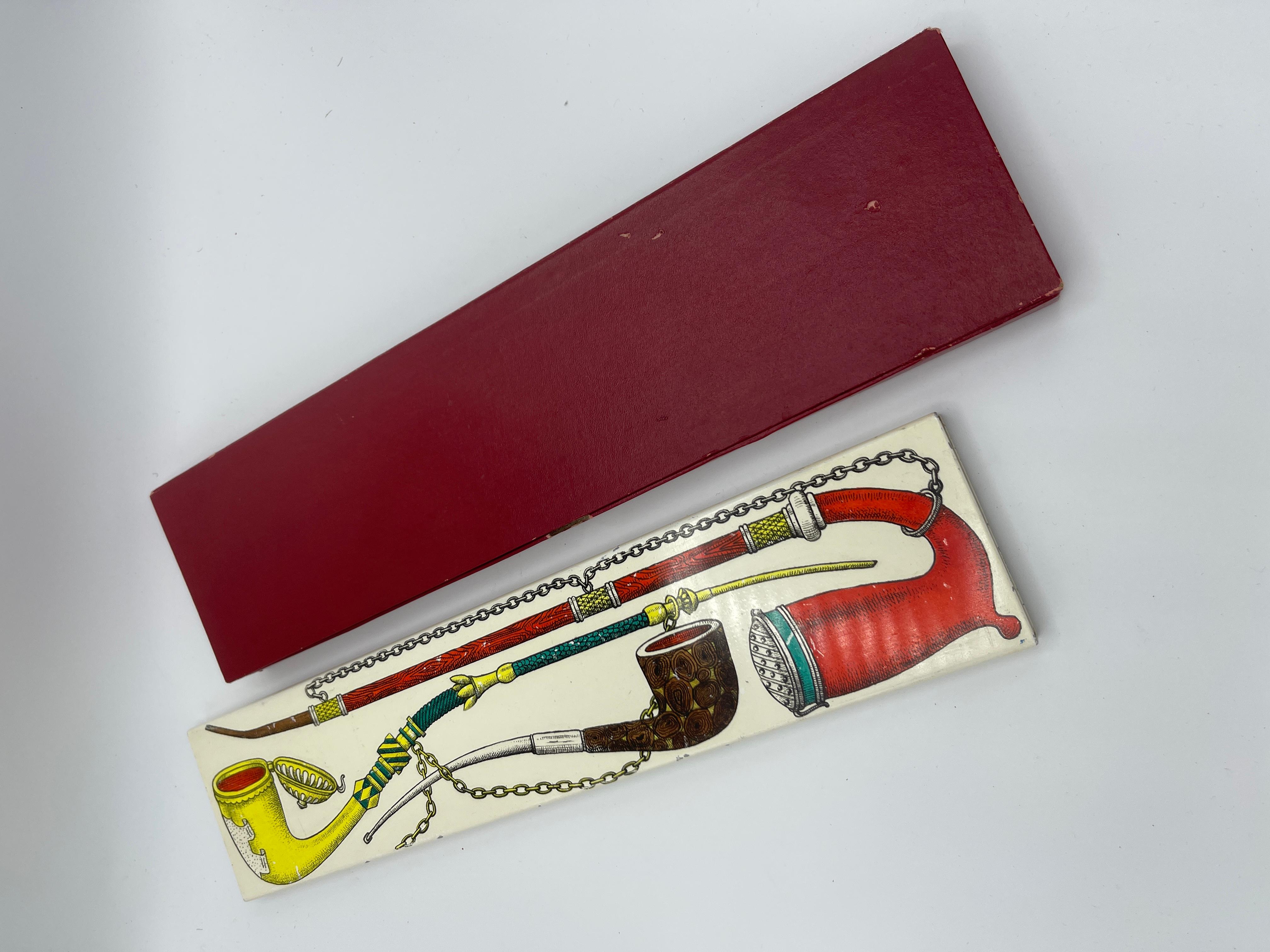 Rare and original metal Boxe by Piero Fornasetti from 50's, decorated with pipes, with the original package. in very good and original condition, used for matches, cigarettes jewelry and more.