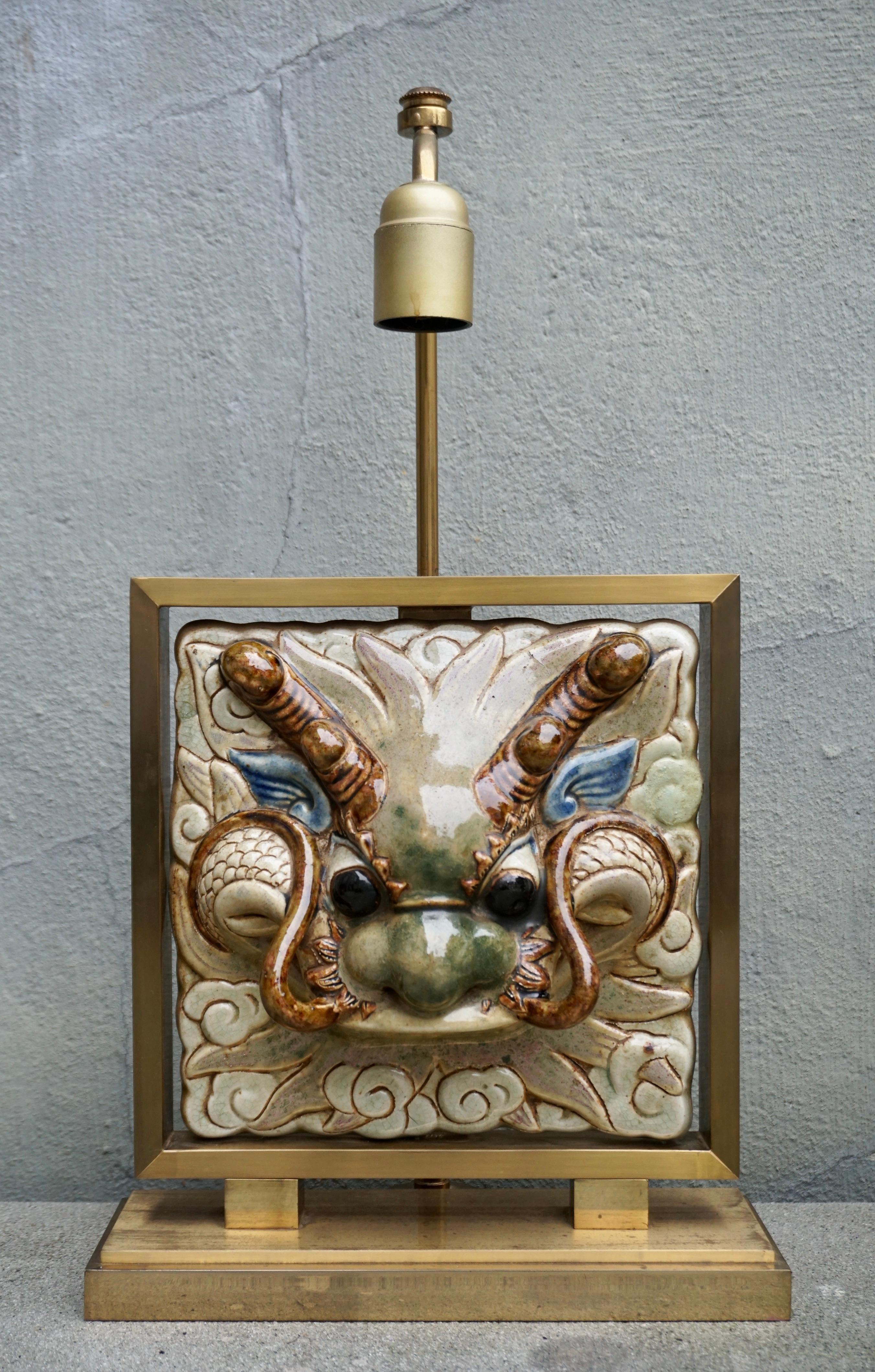 A rare beautiful table lamp with a ceramic dragon head.

Total height 50 cm.
Brass frame height 29 cm.