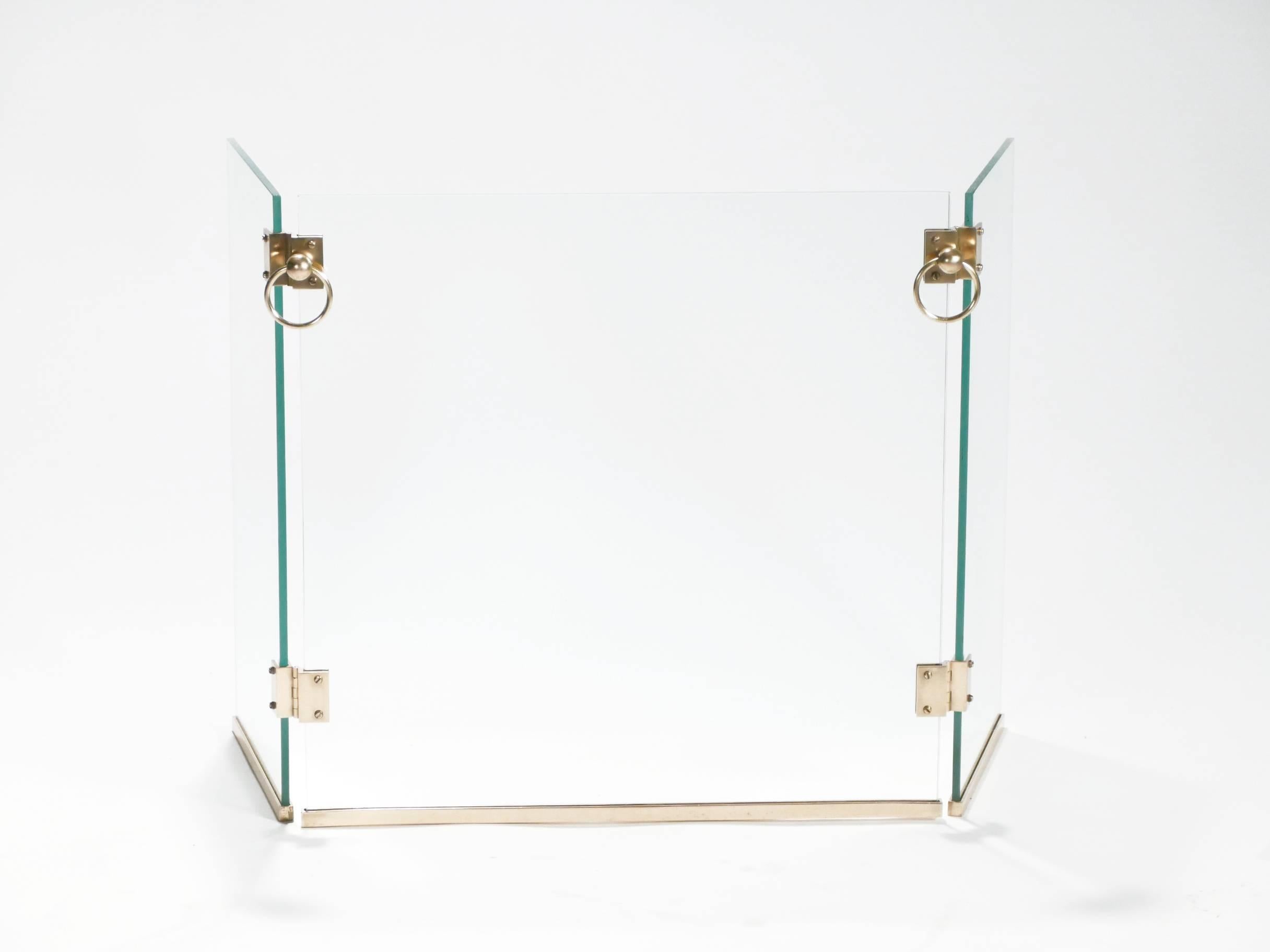 This sharp vintage fire screen is made with transparent glass from Saint Gobain, and quality brass. It’s a rare find and a highly decorative piece, designed by innovative French architect and designer Jacques Adnet in the 1940s. With warm brass
