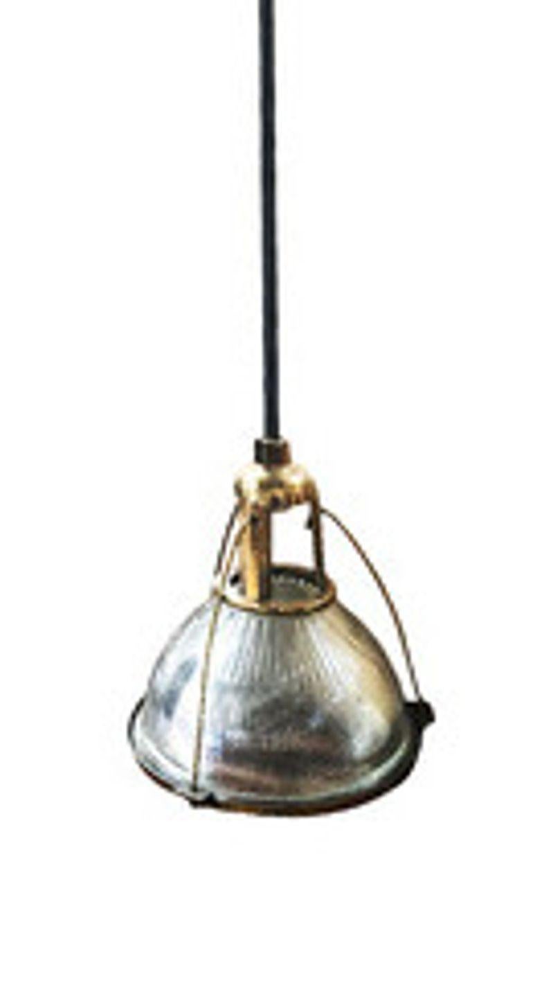 This industrial yet elegant hanging lamp from the 1940s features a Holophane glass shade. The pendant light is connected by an aluminum casing fixed to the top of the light fixture and is a rare brass-plated variant not seen often.

A holophane