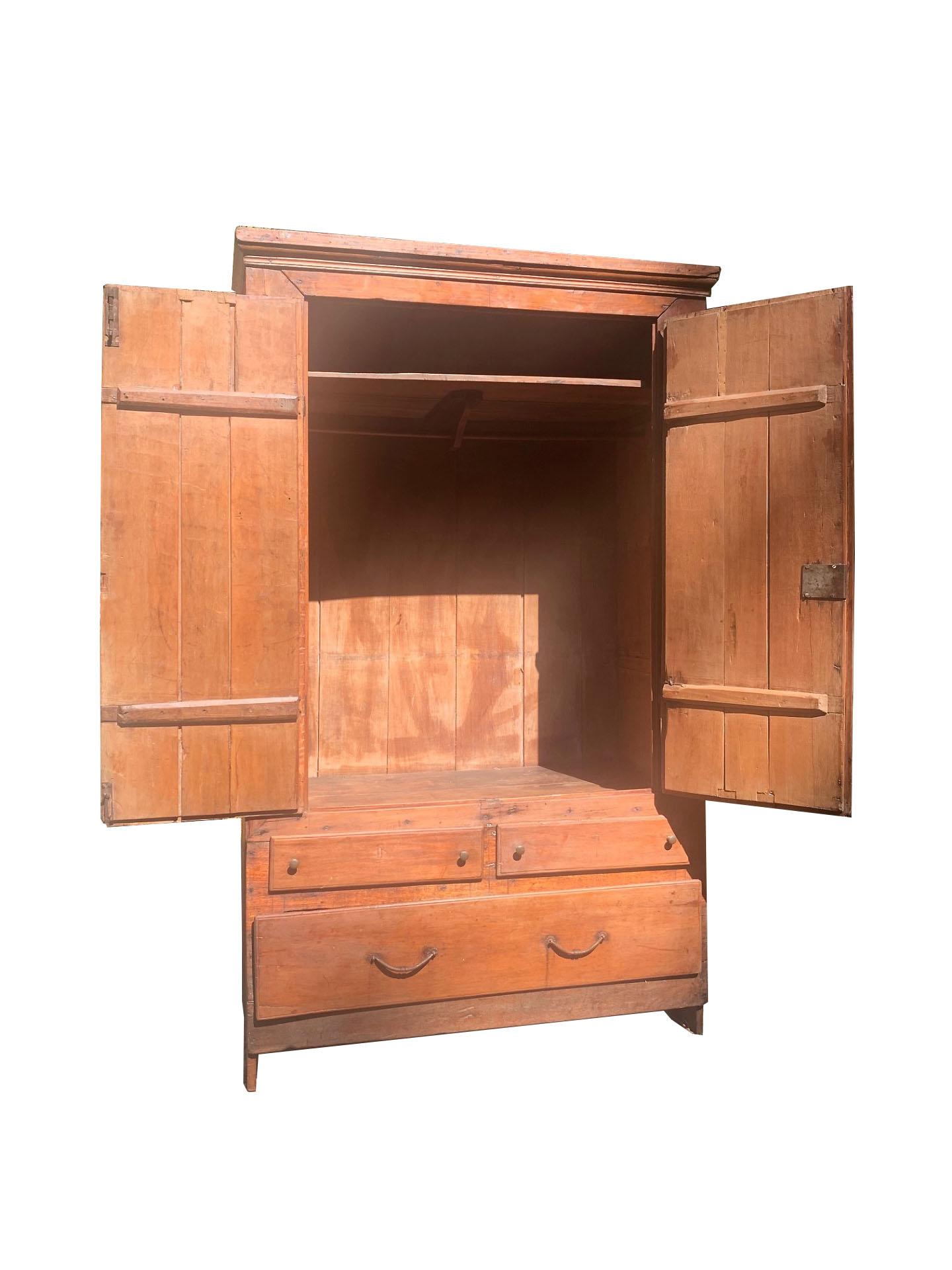 This magnificent late 18th-century Brazilian armoire is a perfect piece for clothing storage, reflecting the timeless elegance of colonial craftsmanship. Constructed from solid wood, it showcases a natural patina and warm tones that speak to its