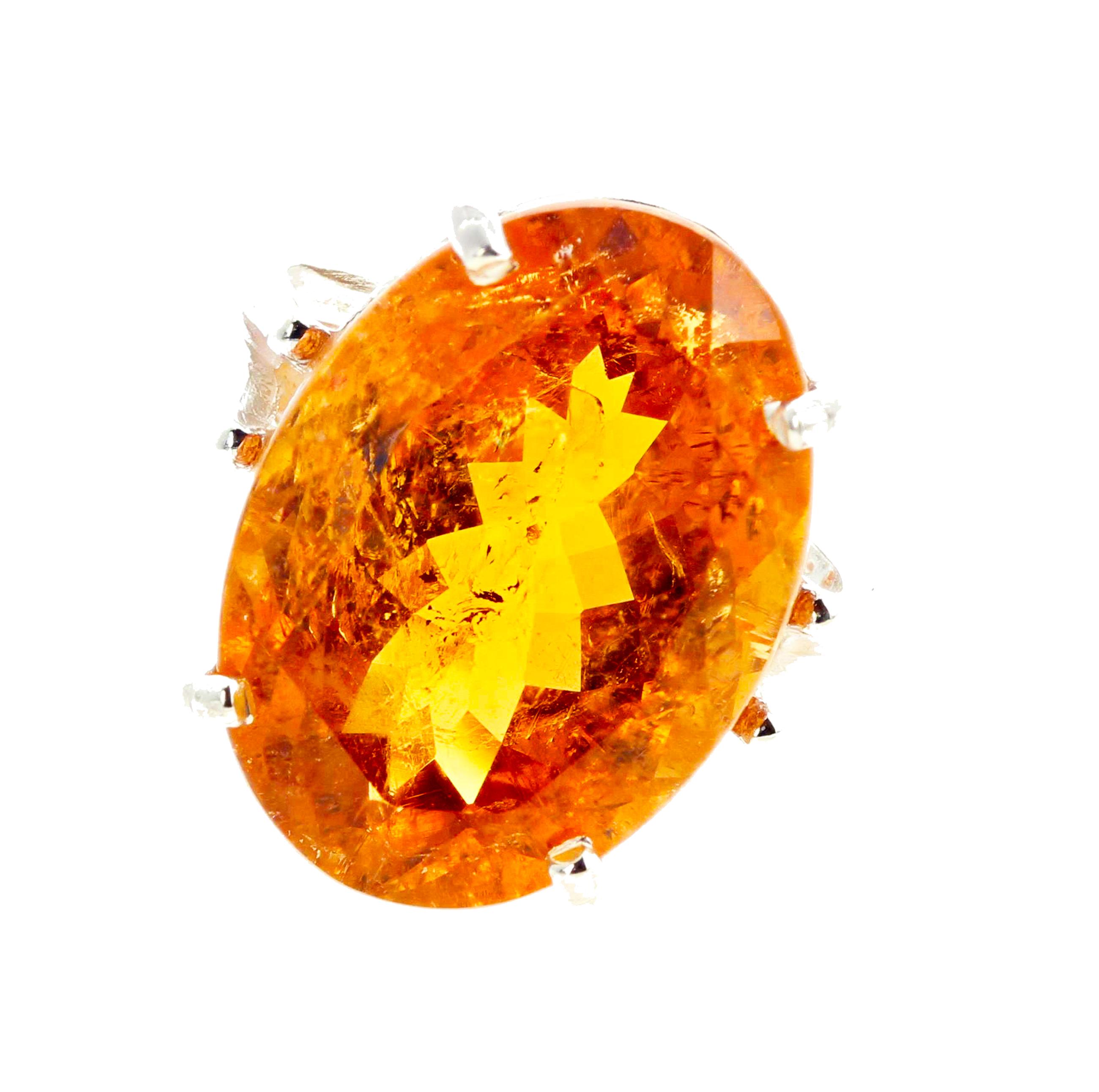 Glittering huge 16.25 carat rare orangy oval sparkling Tourmaline with goldy flecks of light (19.3 mm x 14 mm) set in a lovely sterling silver ring size 7 sizable for free.  The beauty of the quality of the stone is visible through the photograph