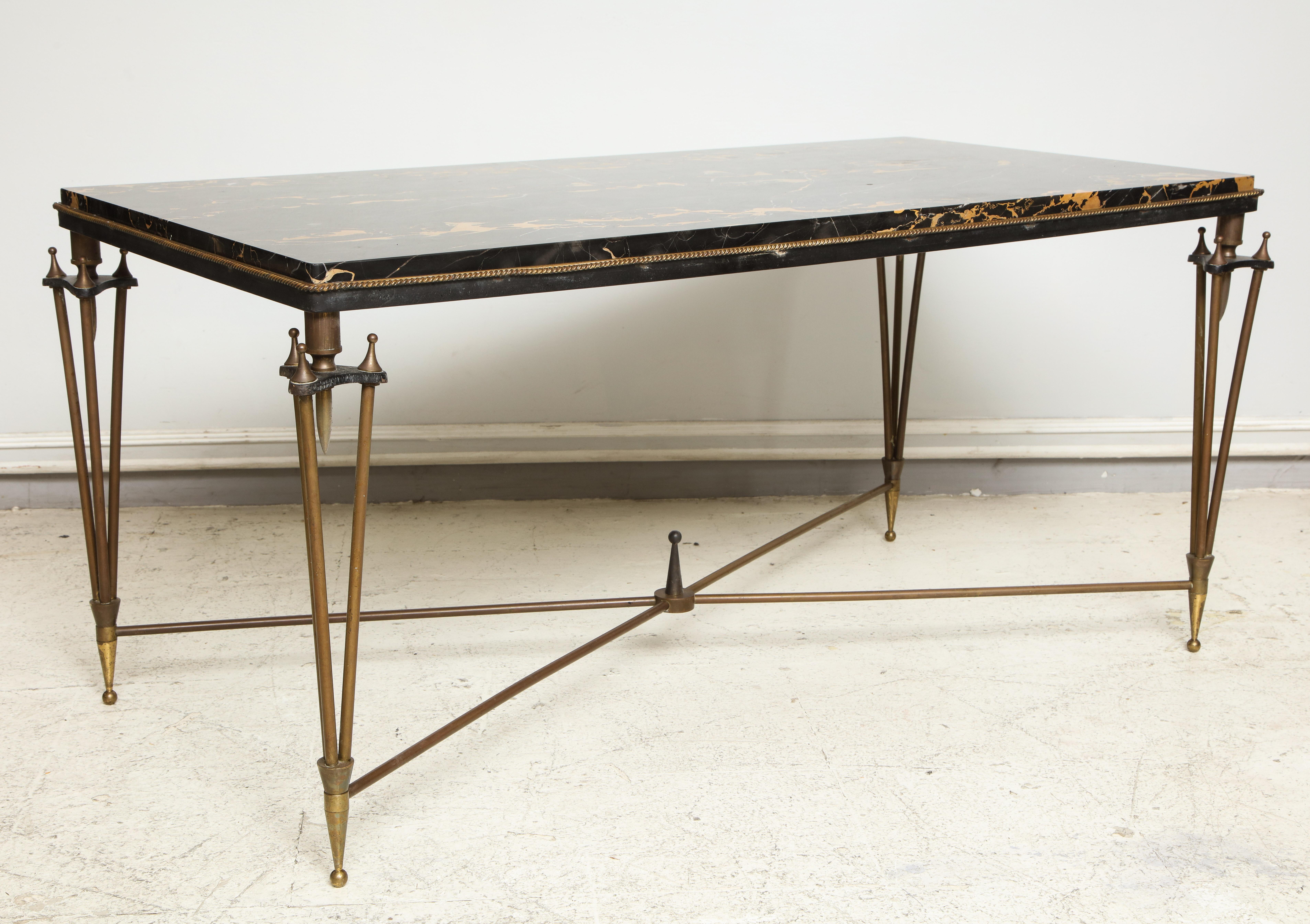 Rare coffee table designed in the style of Gilbert Poillerat, circa 1945, base of bronze and iron with gold and black marble top.