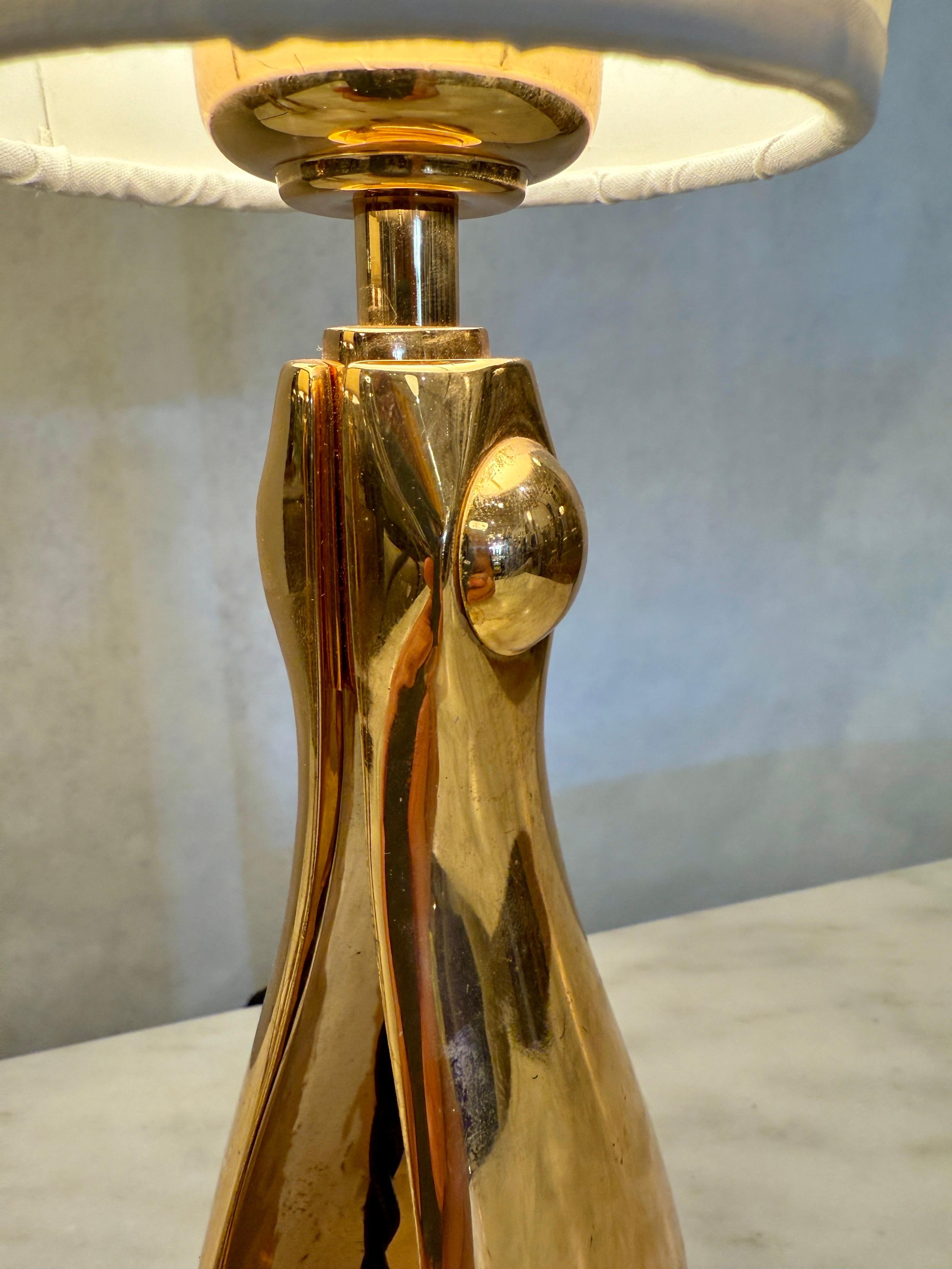These petite table lamps are made of heavy polished bronze in the form of a wish-bone, open to interior and a decorative semi-circle to top.  The NEW paper shades are INCLUDED.  The black silk wiring is new and in wonderful working condition.