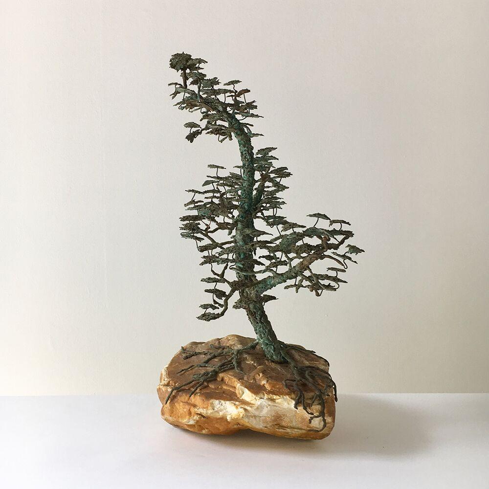 Rare table sculpture in bronze of a Bonsai tree in full leaf mounted on a sand stone colored rocky base with the abundant roots enveloping it in a naturalistic manner, mid-1960s. signed (artist unknown).

Bonsai started in Japan in the 6th