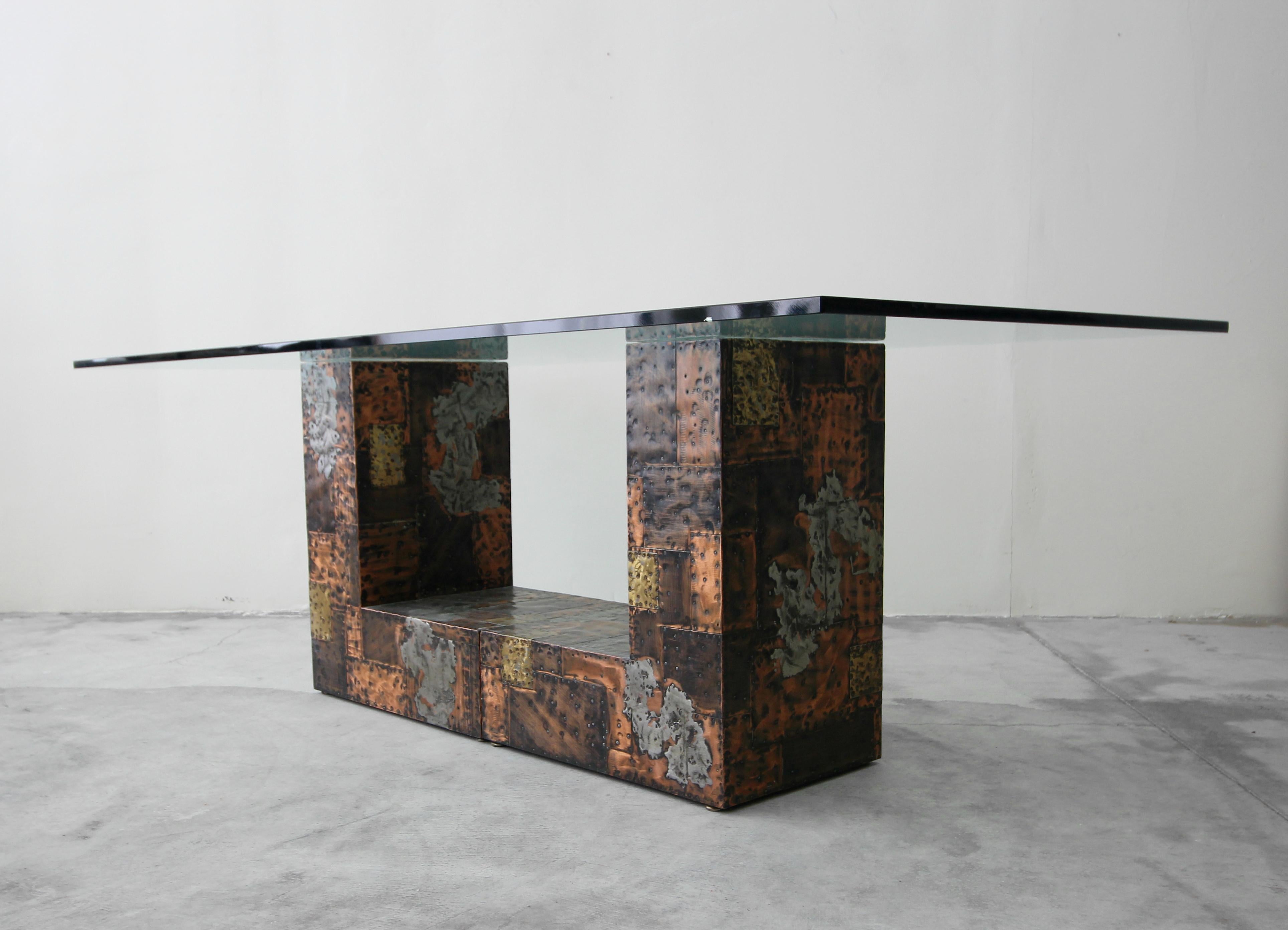 From a one owner estate, comes a rare opportunity to own an authentic and very rare Brutalist metal patchwork pedestal dining table by Paul Evans. Table is comprised of 2 L-shaped pedestals clad, in rivited bronze, copper, brass and pewter pieces in
