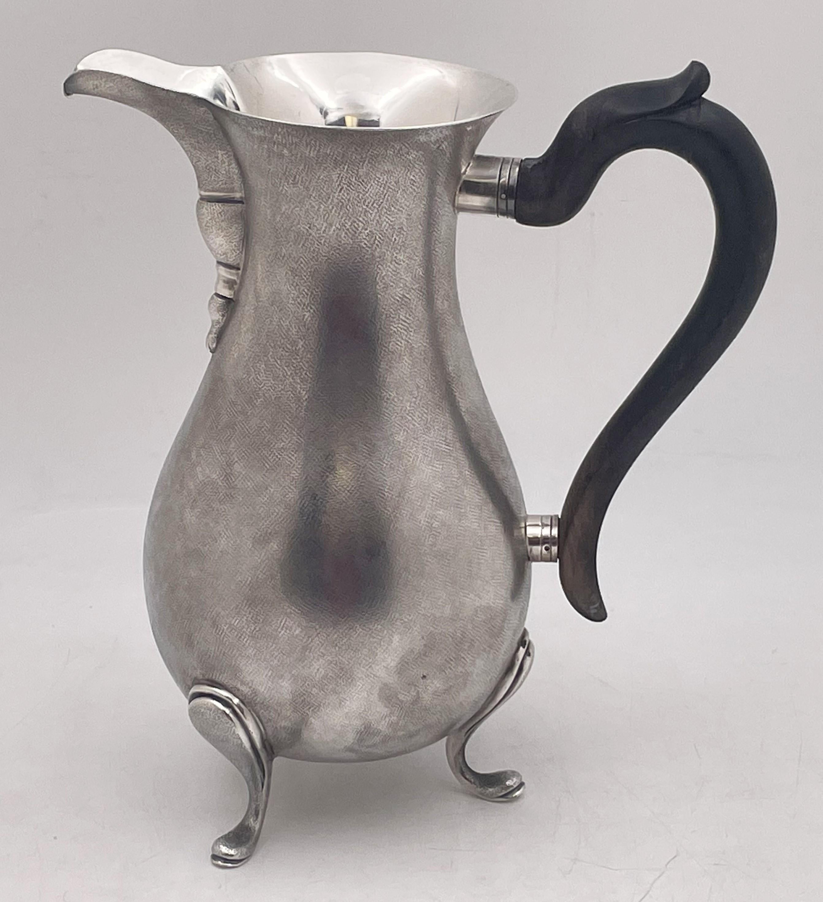 Buccellati, sterling silver bar pitcher, made in a rare Buccellati technique with satin finish, with a wood handle, standing on 3 curvilinear legs. It measures 9 1/2'' in height by 8 1/2'' from handle to spout, weighs 28.6 troy ounces, and bears