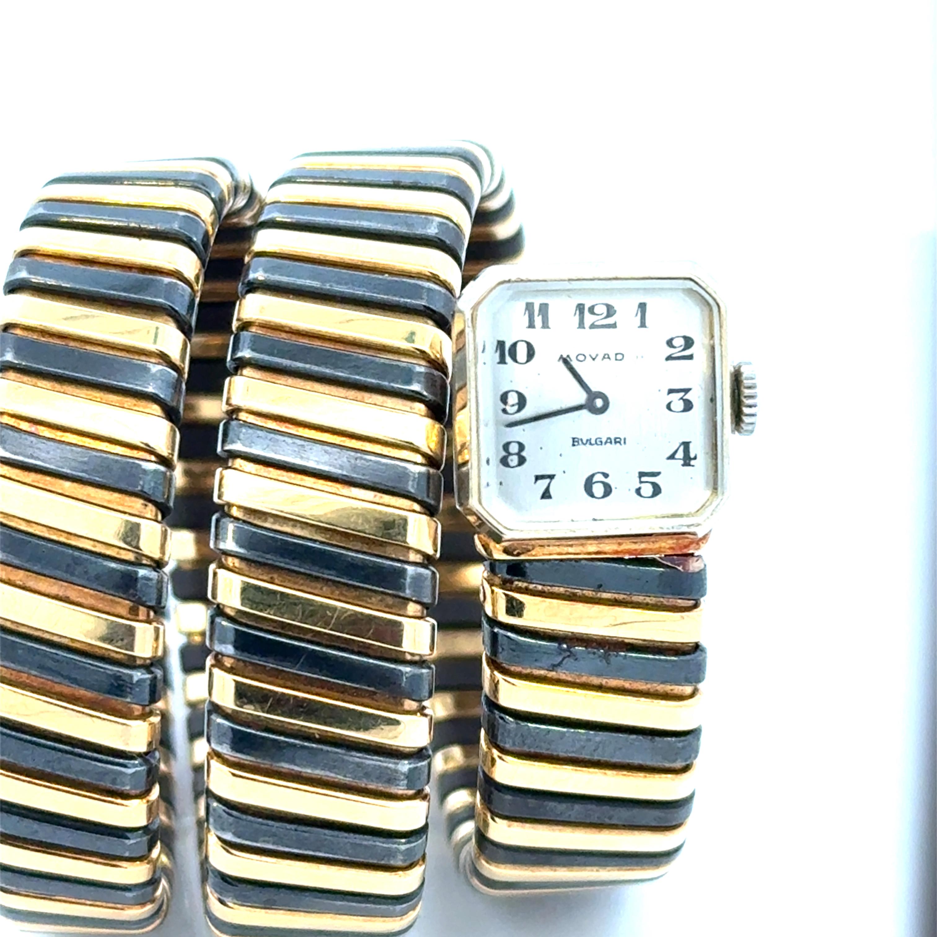Rare montre bracelet serpent Bulgari Tubogas pour dame en or jaune et noirci 18k. 
Ce manuel enroule  La montre a une forme carrée rare et inhabituelle  et un cadran gris immaculé. 
Une montre emblématique que vous porterez pour toujours. 
1975