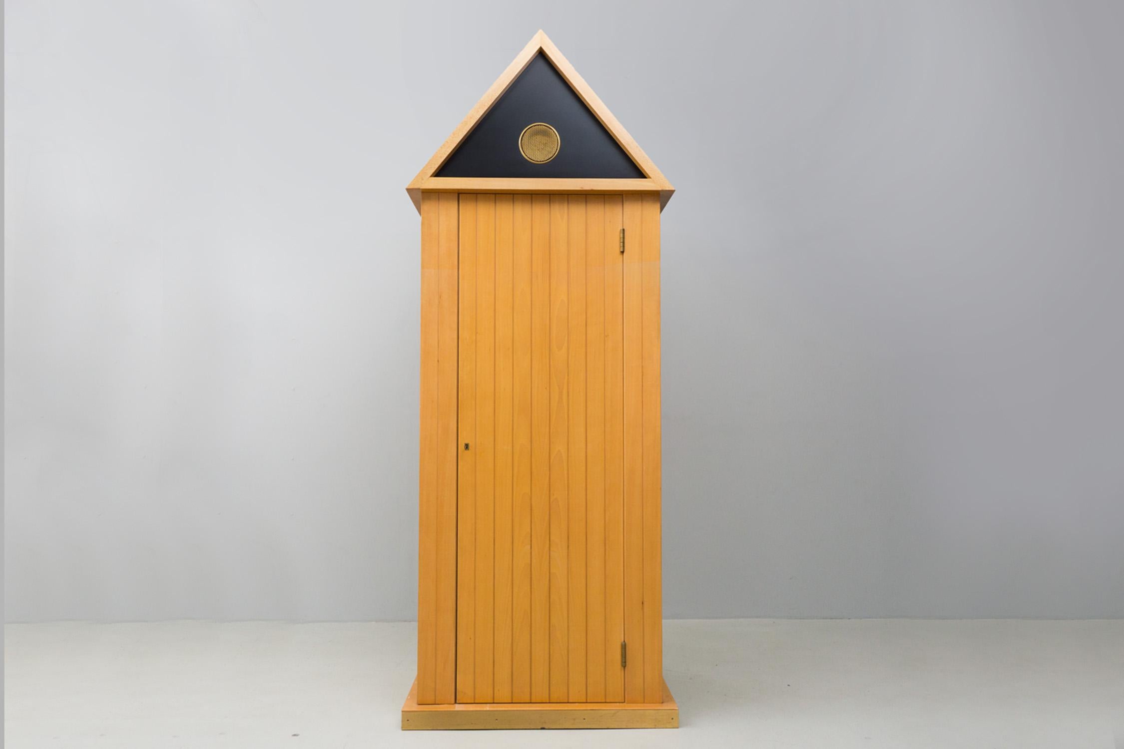 Questo raro ed eccentrico armadio è realizzato in legno massiccio, ha cassetti e ripiani e un appendiabiti. La porta può essere chiusa con una chiave. Finiture in ottone sulla parte superiore e sul piede. Prodotto in Cantú da Bruno Longoni.

Aldo