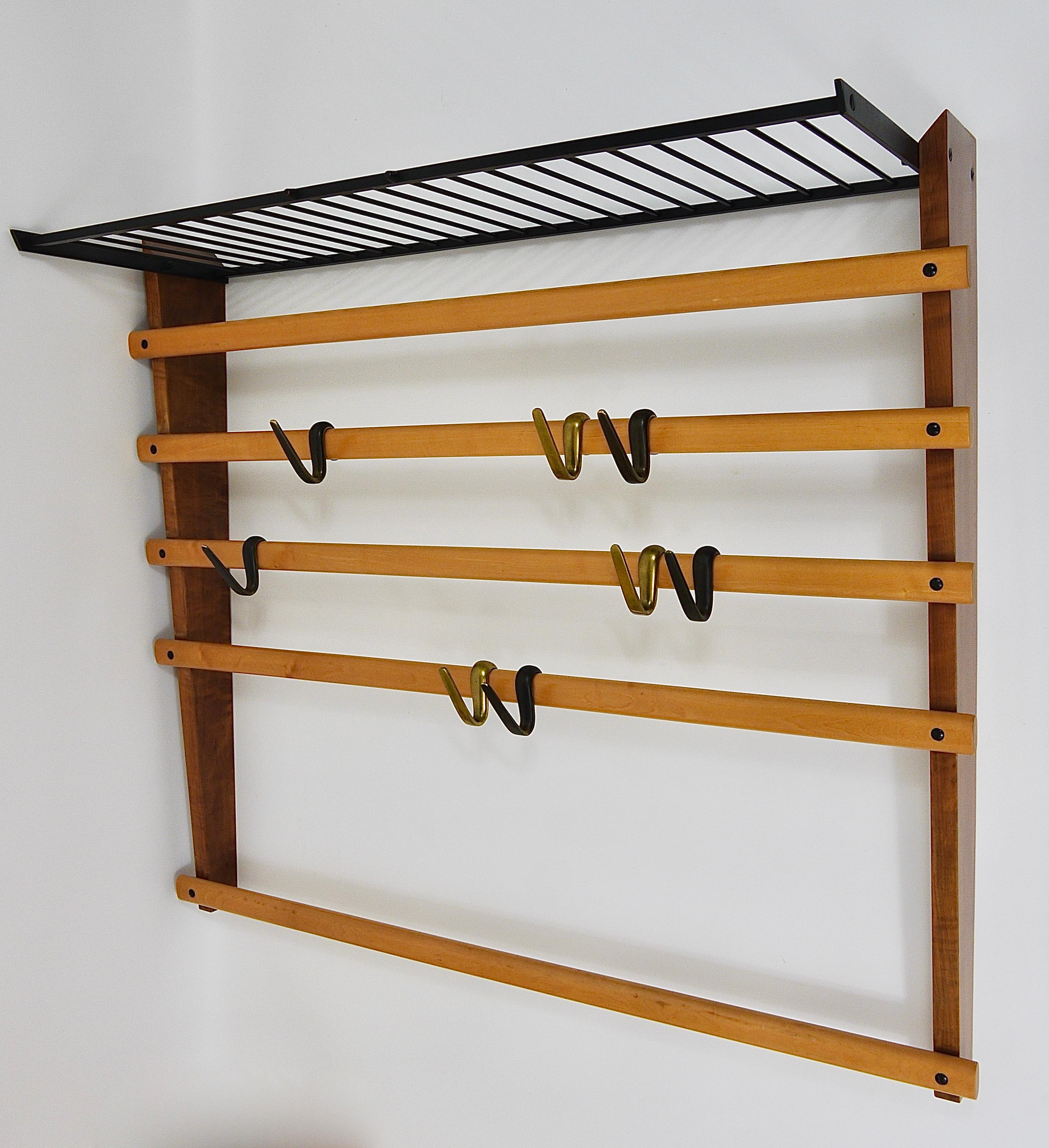 An elegant modernist wall-mounted coat rack from the 1950s. An original and old vintage object, designed and executed by the Austrian architect and designer Carl Auböck. This is a unique version, which has an additional integrated hat rack. This is