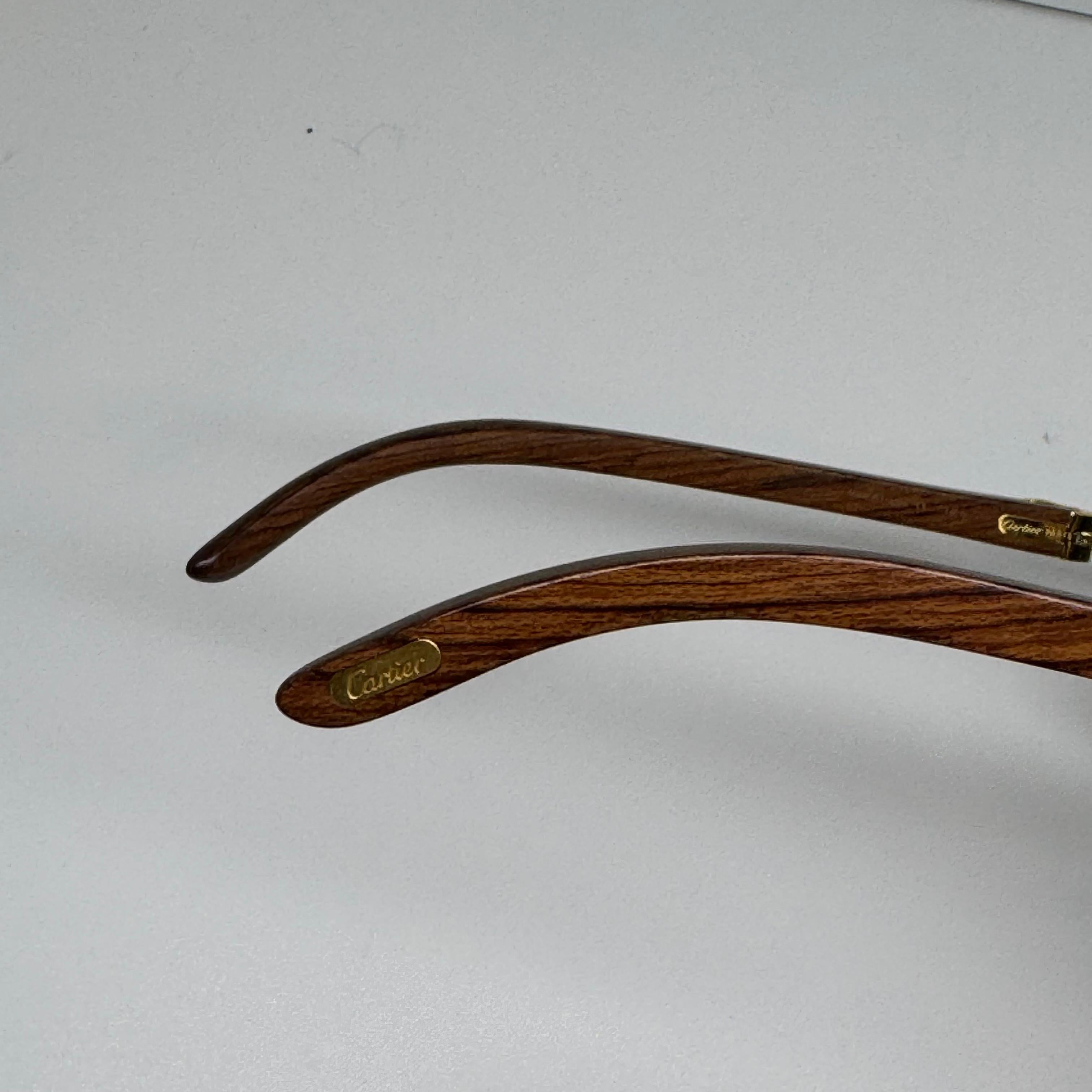 Beautiful cartier 140B rimless sunglass. Wooden stem with gold hardware. Comes with cartier box and care booklet. Missing its leather case.