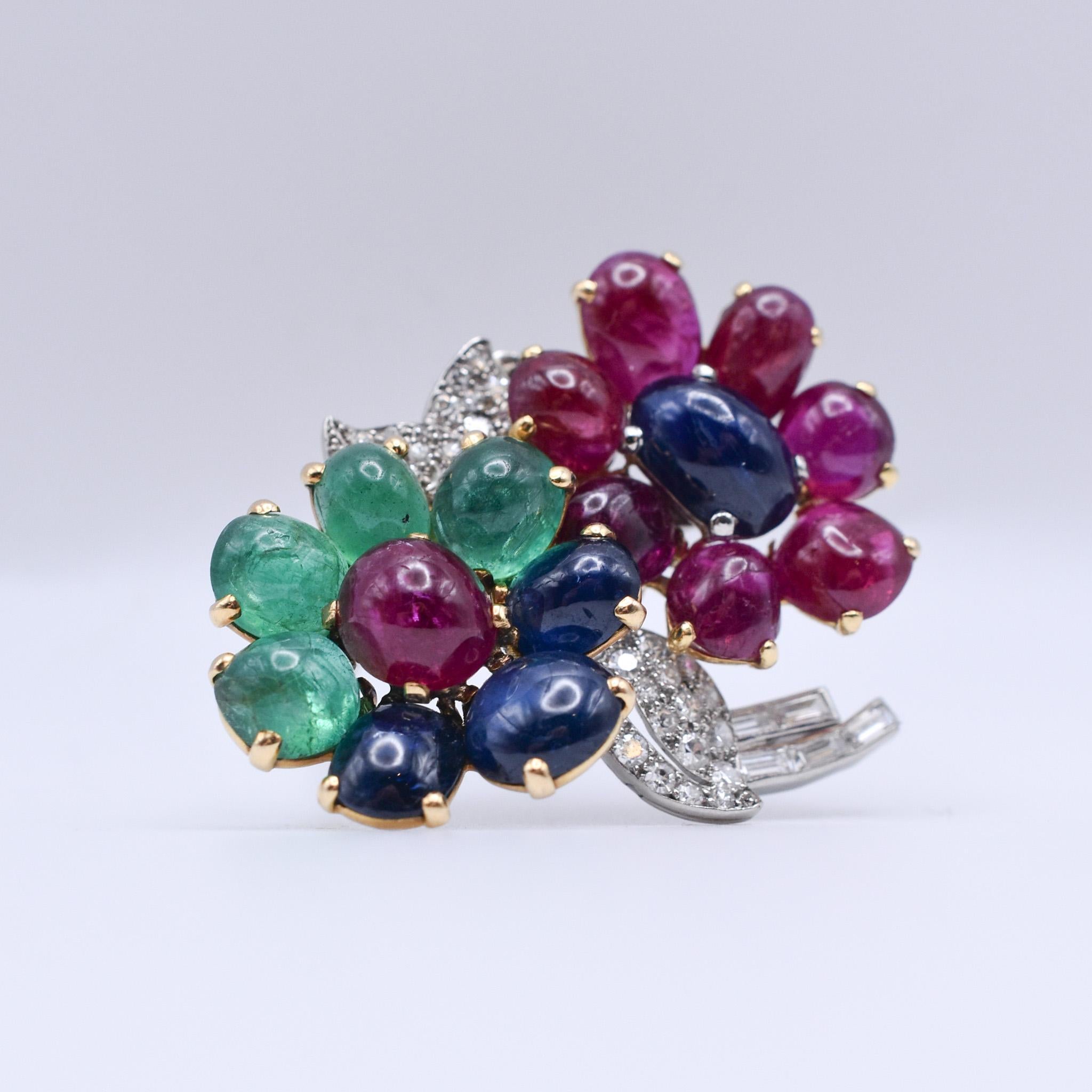 A beautiful, rare and collectible floral brooch by Cartier, with cabochon rubies, emeralds and sapphires, highlighted by diamonds. Made in Paris, circa 1930.