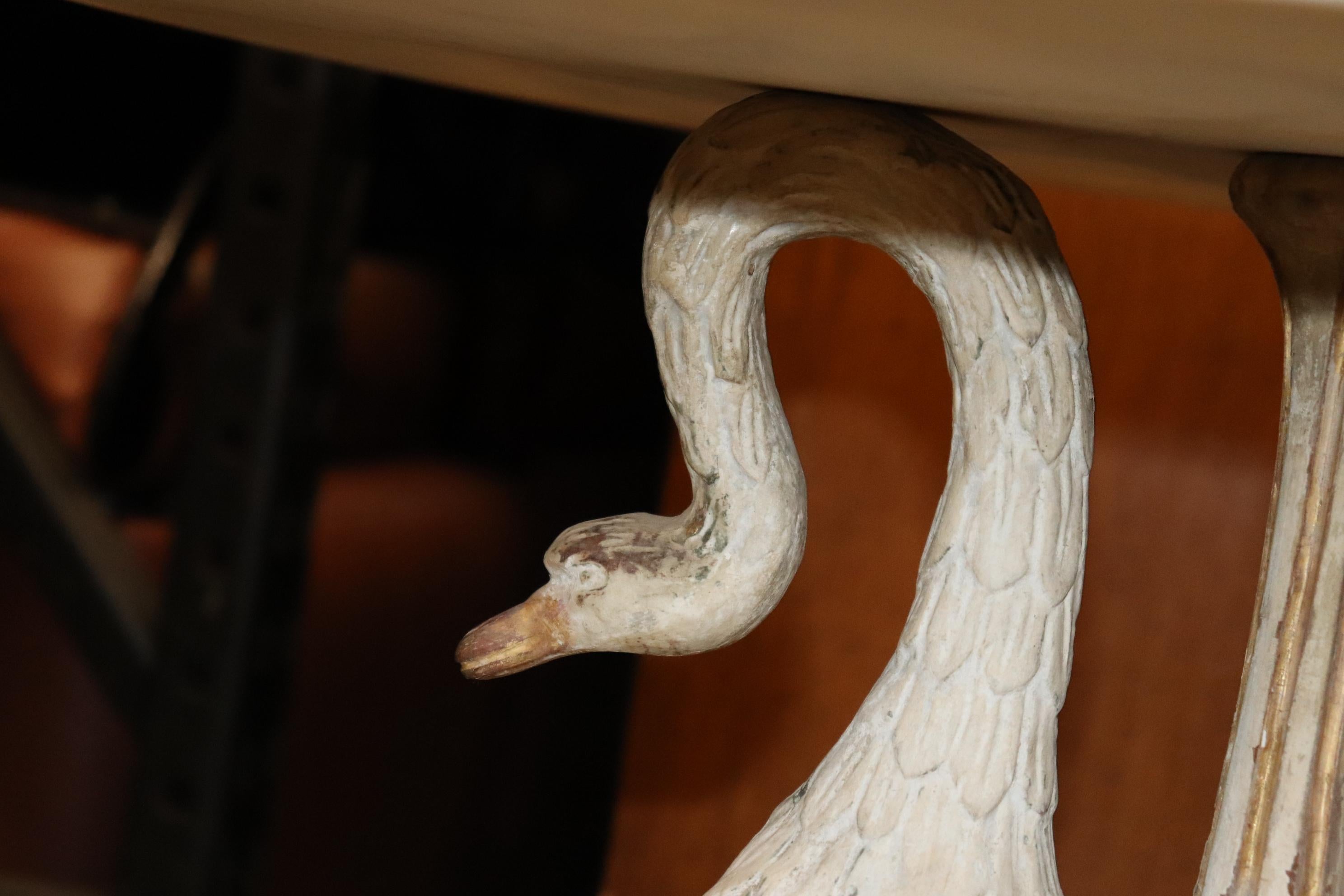 This is a superbly carved full-bodied set of 3 swans all painted and done in realistic fashion. The swans are surmounted by a marble top that is fitted with a brass decorative top. The table measures 24 x 24 x 24 and is a very rare and unique and
