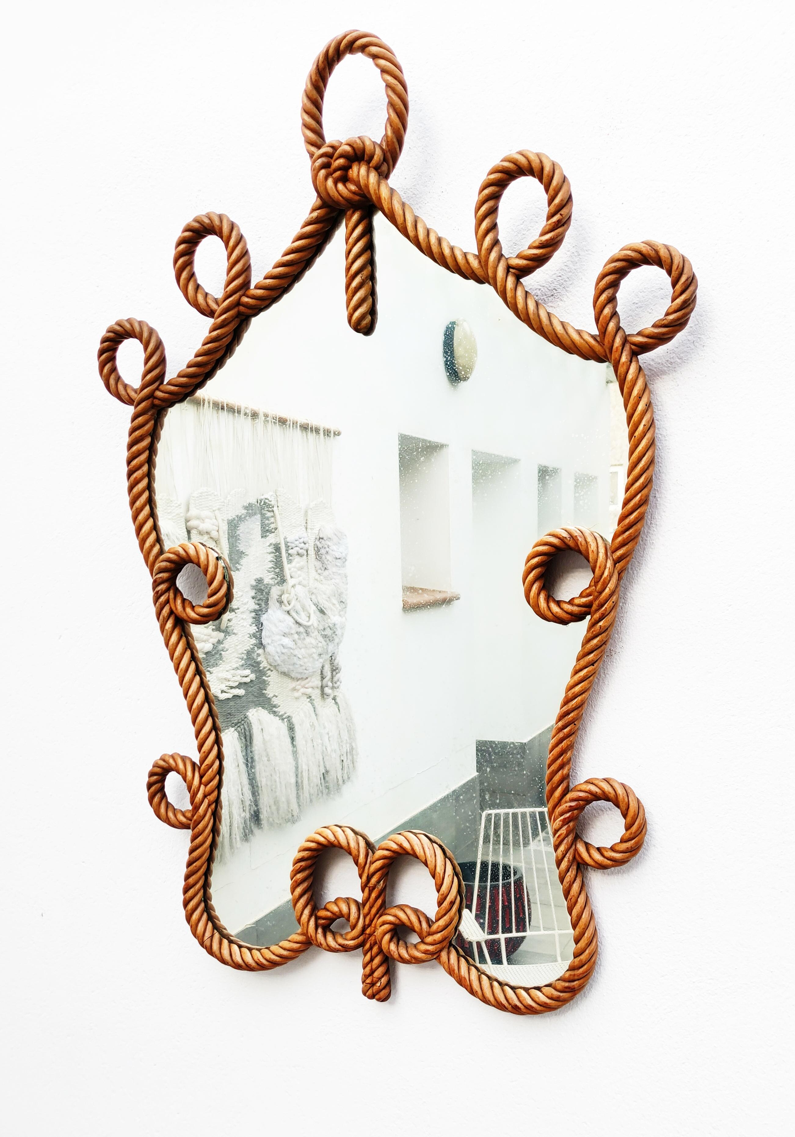 Beautiful and rare carved rope mirror, hand made in Spain in 1940s. Work of incredible finesse, in very good vintage condition. The mirror is old and a little pitted over its entire surface.