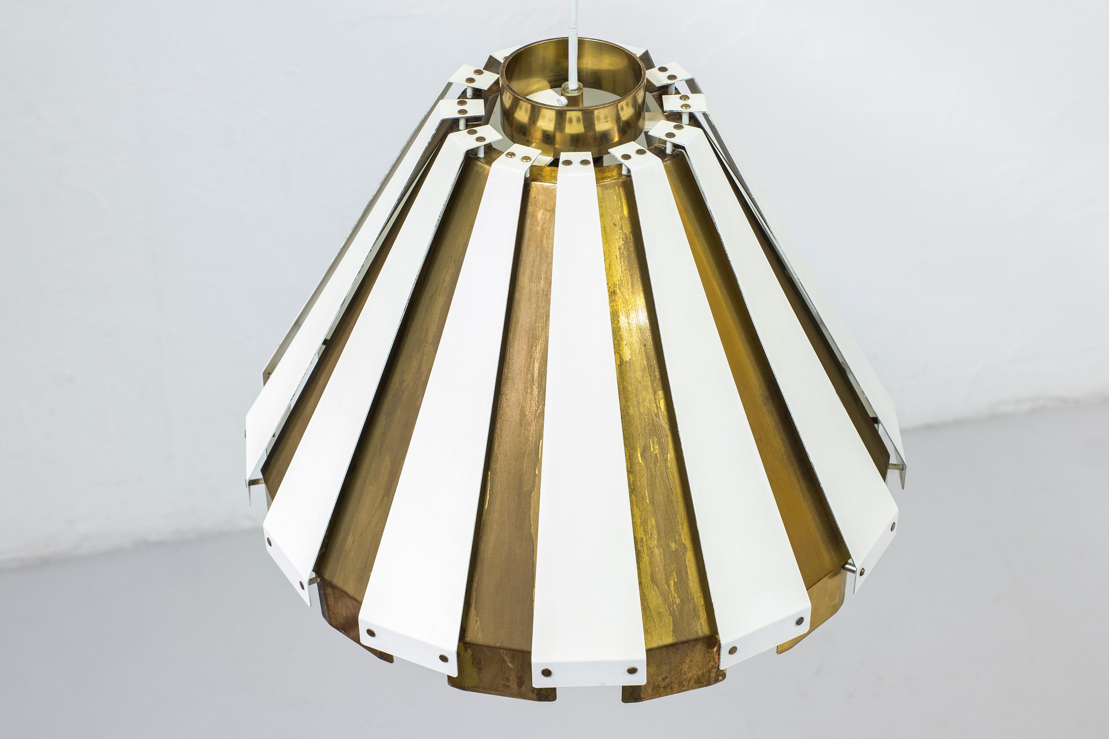 Rare ceiling lamp designed by Hans Agne Jakobsson. produced by his own company in Sweden during the 1950s. Made from white lacquered aluminum and brass. Original ceiling mount with label. Good vintage condition with some age related wear and