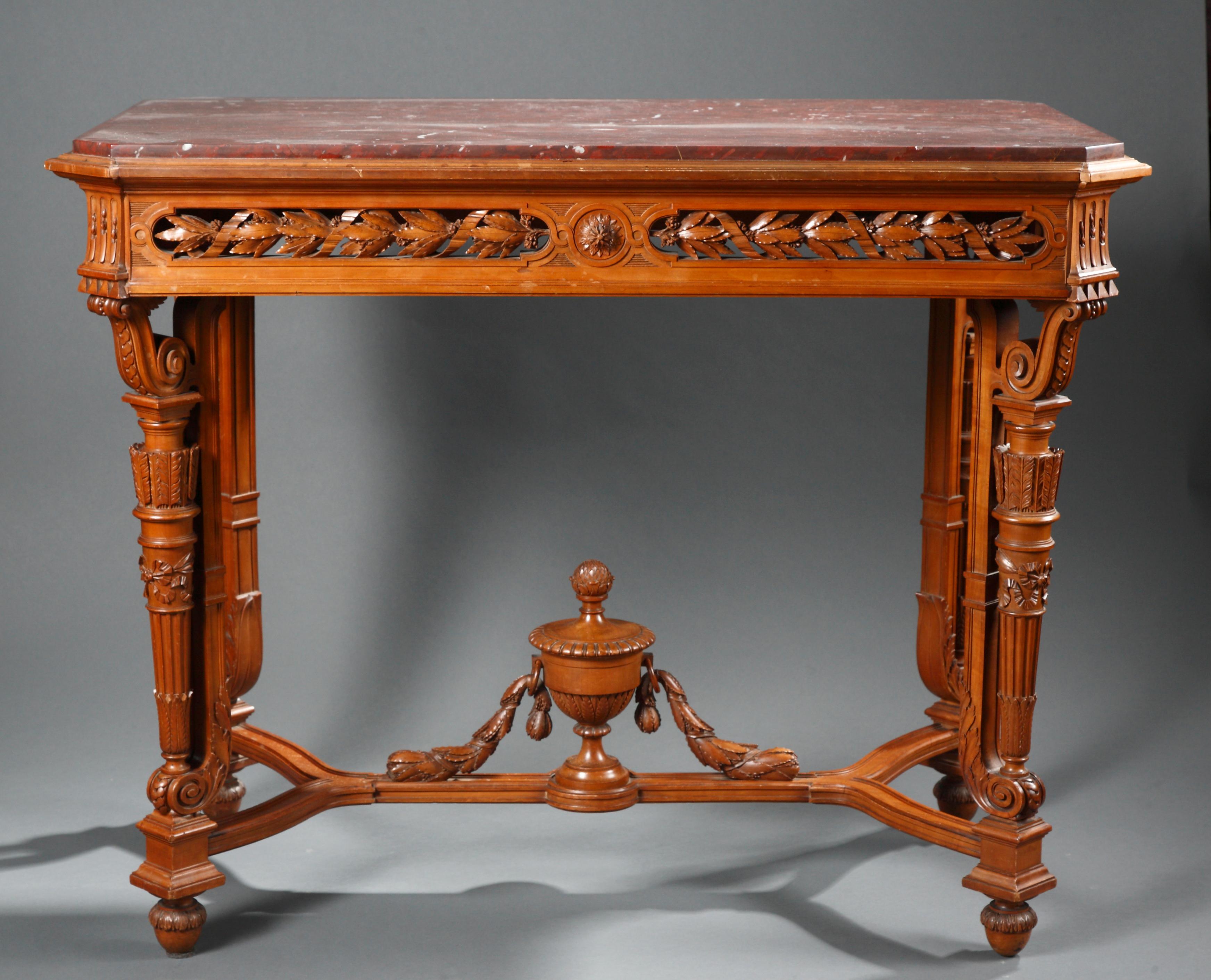 Center table made exclusively in richly carved wood and attributed to A.E. Beurdeley ; with a fine pierced belt ornamented with laurel branches. Raised on four legs joined by a stretcher, centered by a carved wood vase. Topped with a red Griotte