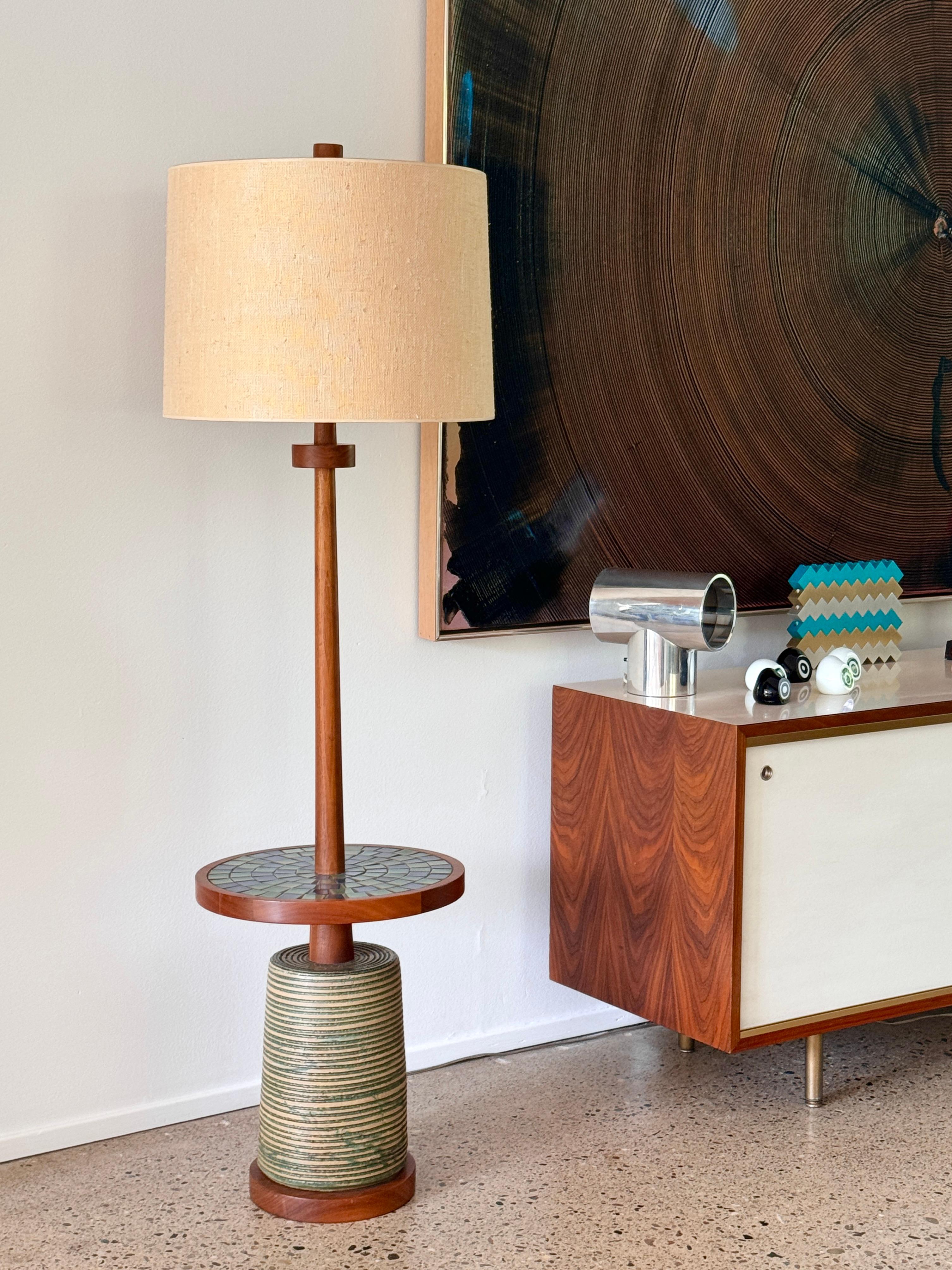 Rare walnut and ceramic floor lamp with floating mosaic table by Gordon and Jane Martz for Marshall studios circa 1960s

Model 164 in walnut with striated glazed stoneware base and floating mosaic table in a brilliant arrangement of blue and green