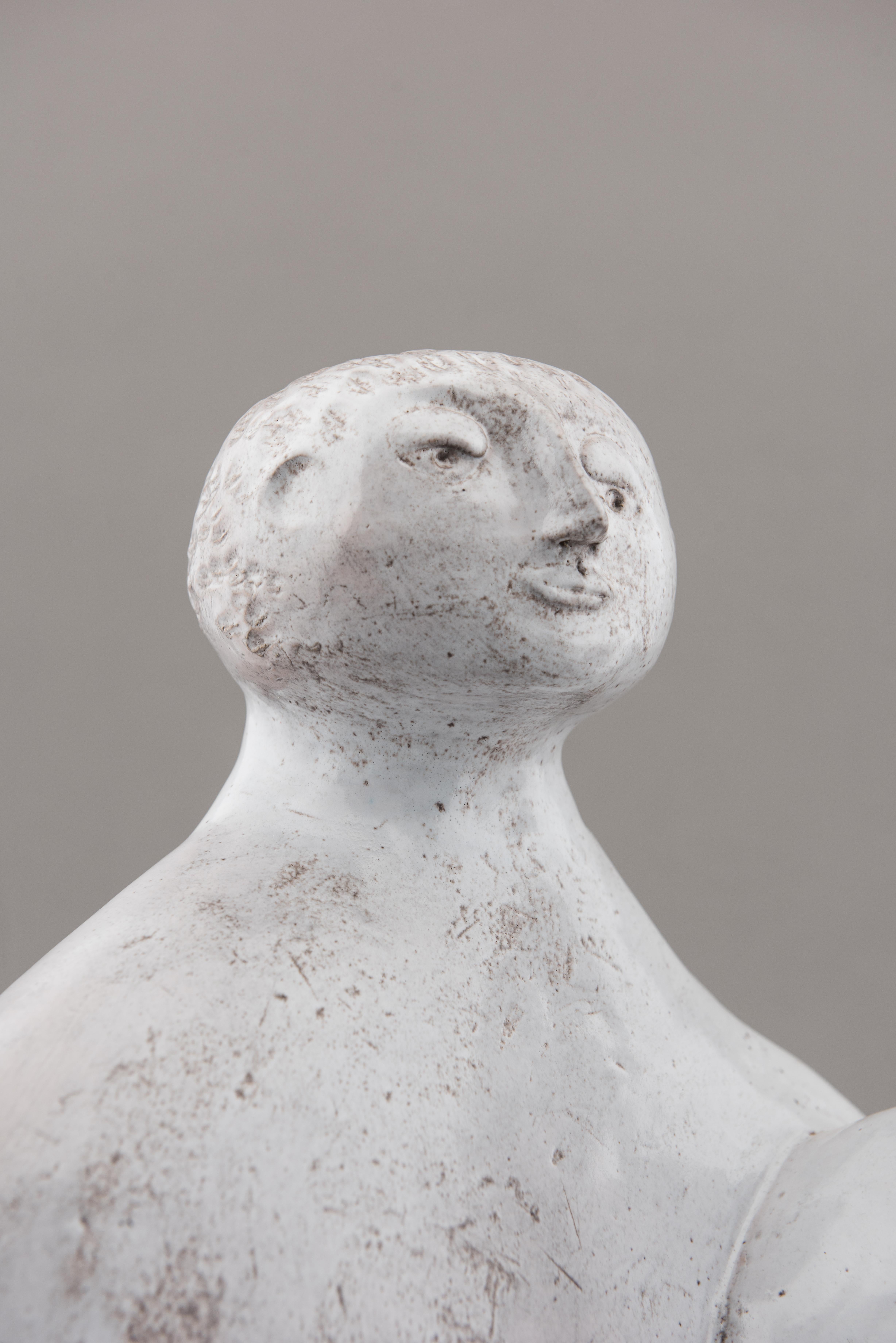 Unique piece by Robert and Jean Cloutier, post-war French ceramists, coming directly from the artists' family estate. 
Anthropomorphic sculpture of a naked couple sitting and embracing. Naïve design, milky white enamel.
Signed 