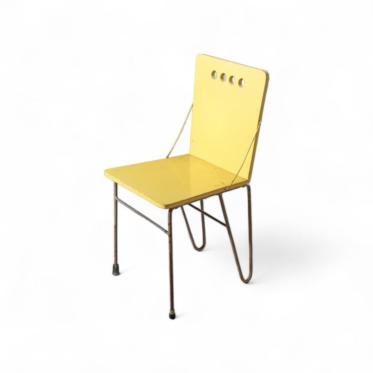 Questa rara sedia, progettata da Gerrit Rietveld Jr., fonde perfettamente la funzionalità modernista con dettagli innovativi. Caratterizzata da una seduta e uno schienale in compensato dipinto di giallo e sostenuta da gambe metalliche minimaliste, è