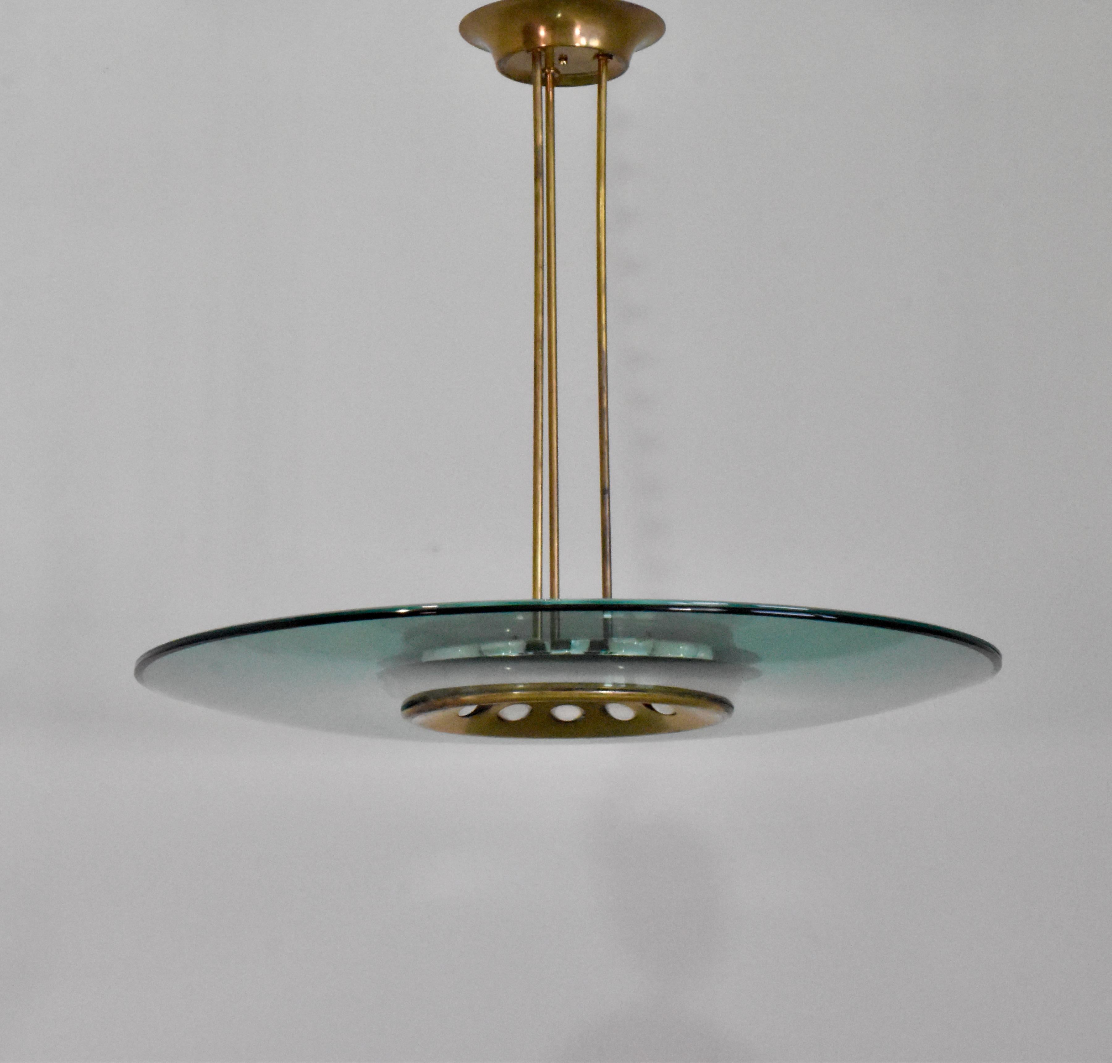 Beautiful Fontana Arte chandelier model 1508 designed by Max Ingrand. Composed of a green concave glass shade and a clear glass top. 
The glass top creates the aqua color edge and prevents dust from settling on the green shade. 
The frame is brass