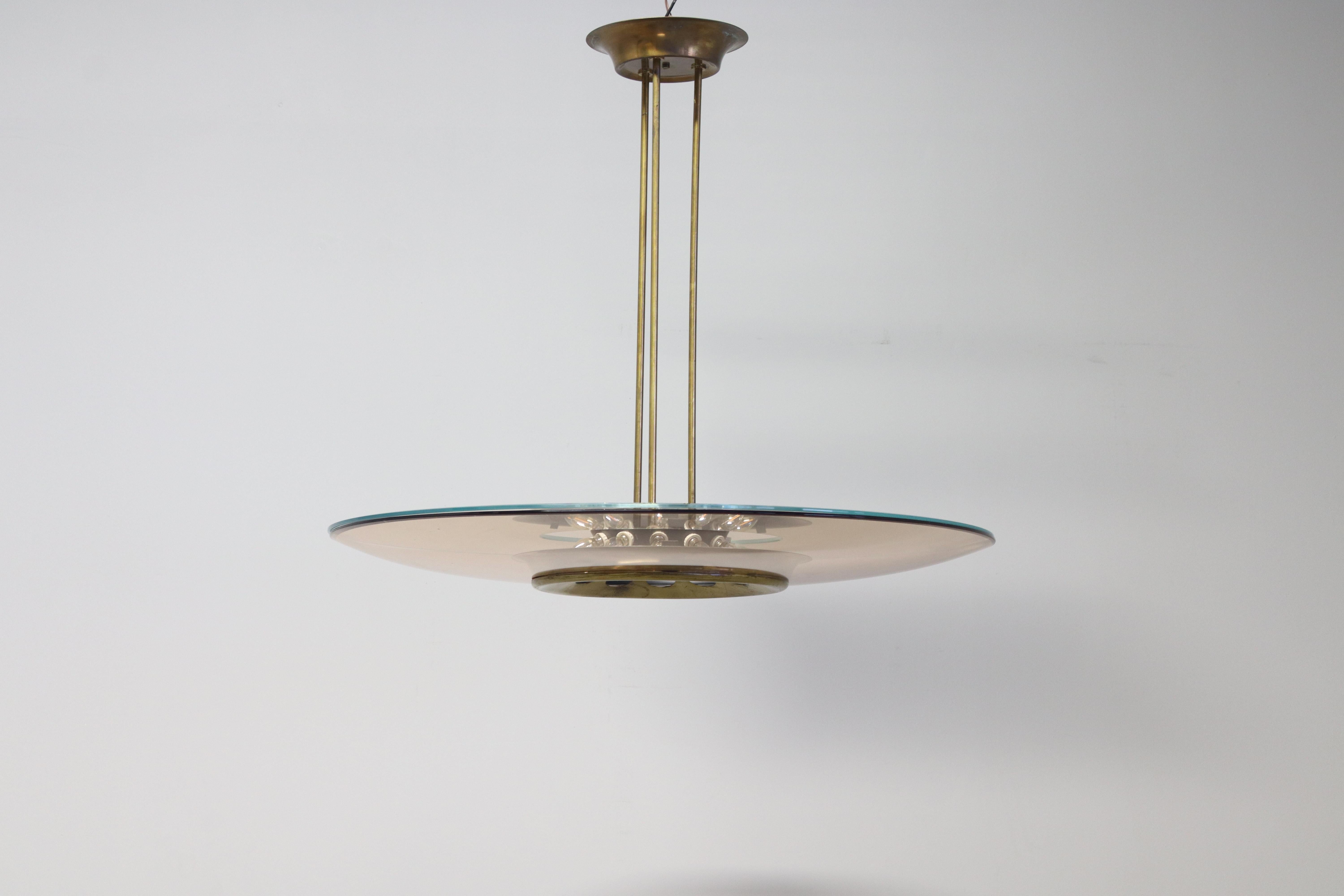 Beautiful Fontana Arte chandelier model 1508 designed by Max Ingrand. Composed of an green concave glass shade and a clear glass top. 
The glass top creates the rose color edge and prevents dust from settling on the green shade. 
The frame is brass