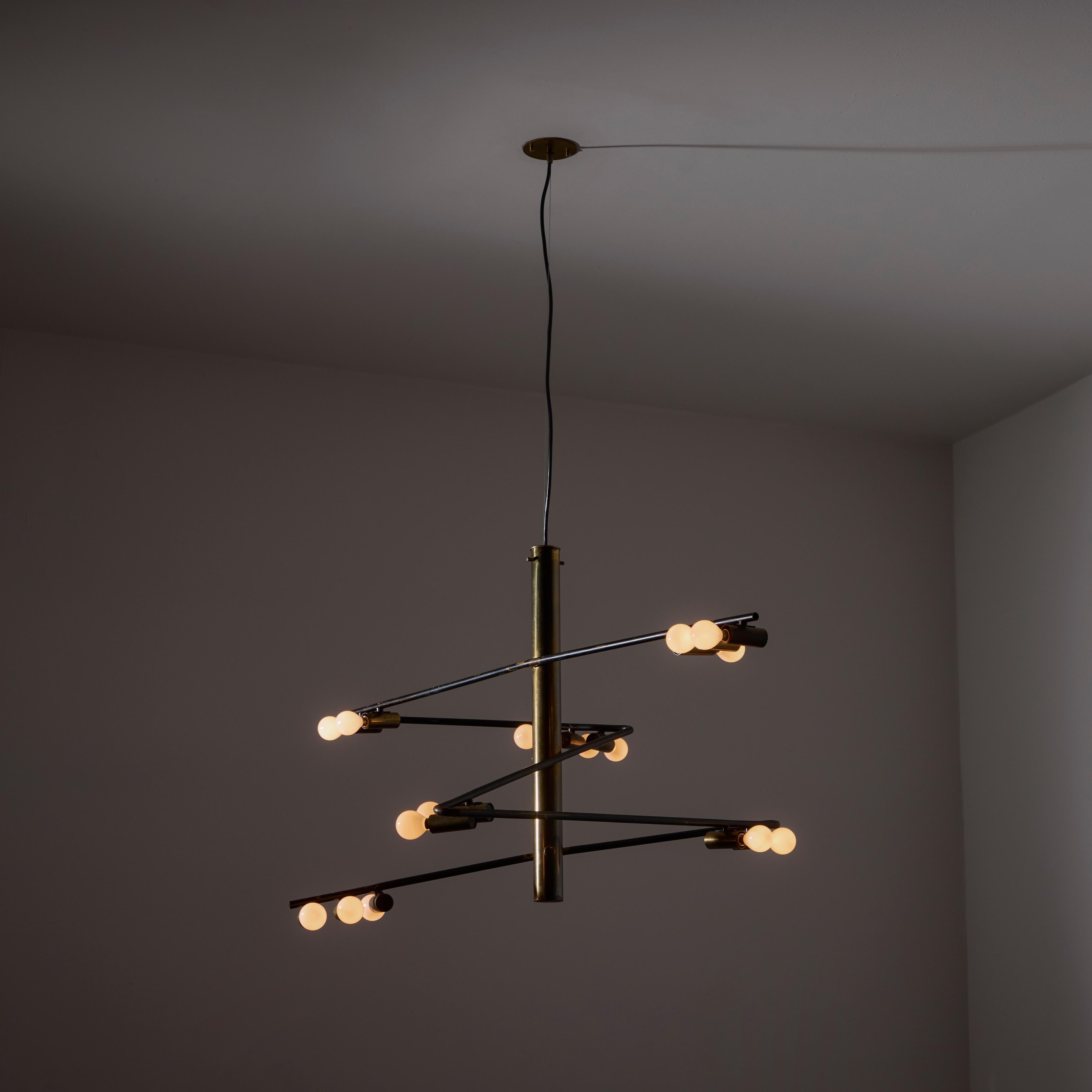 Rare Chandelier by Giampiero Aloi for Stilnovo. Designed and manufactured in Italy, circa the 1950s. Cascading zig zag design; exposed bulb armatures. Aged polished brass with black enamel finishing detail. Fifteen sockets total the chandelier's