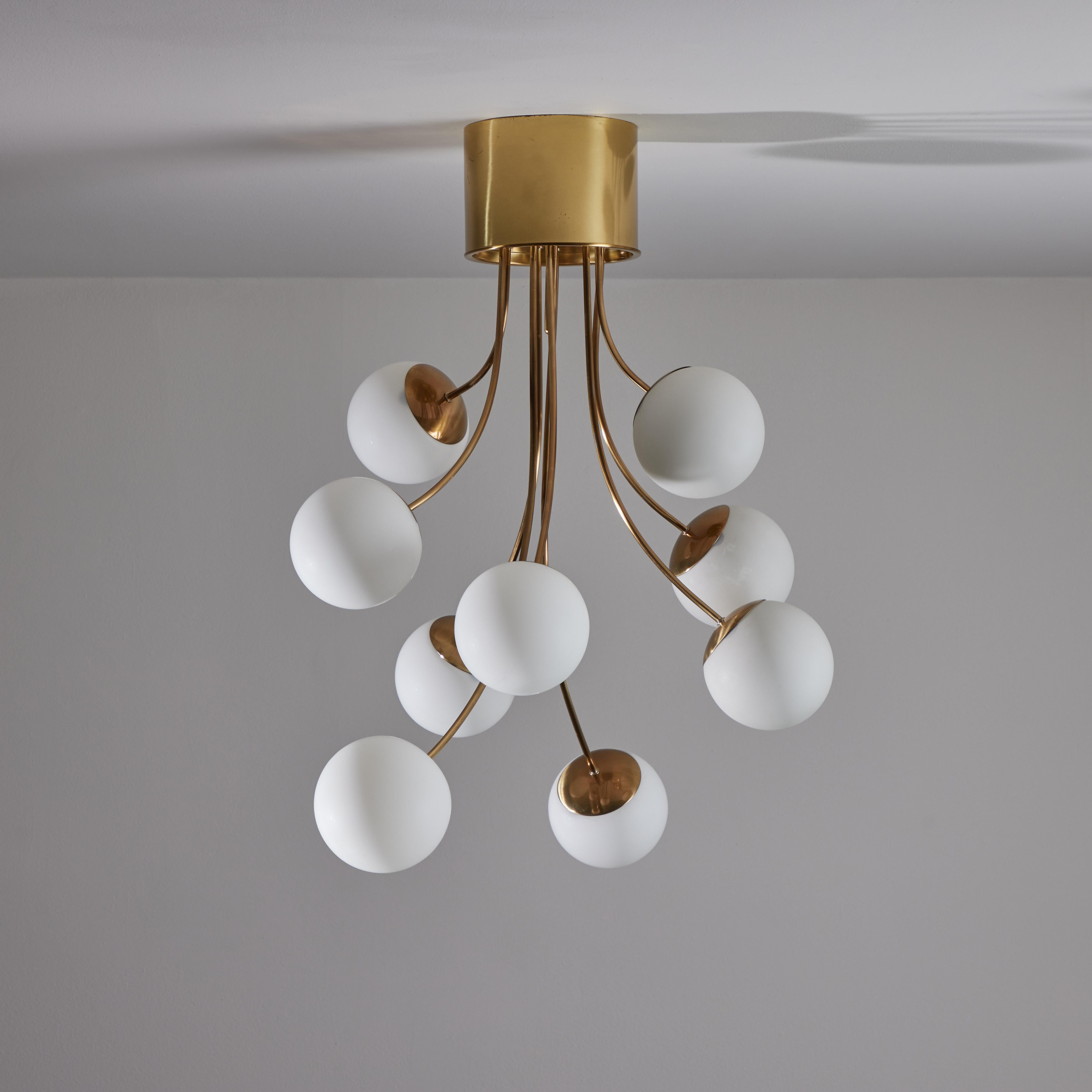 Rare chandelier by Pia Guidetti Crippa for Lumi. Strong similarities to the Model 1036/15 floor and table lamps. Designed and manufactured in Italy circa the 1970s. Polished brass housing with single pole rods extending out for every light globe.