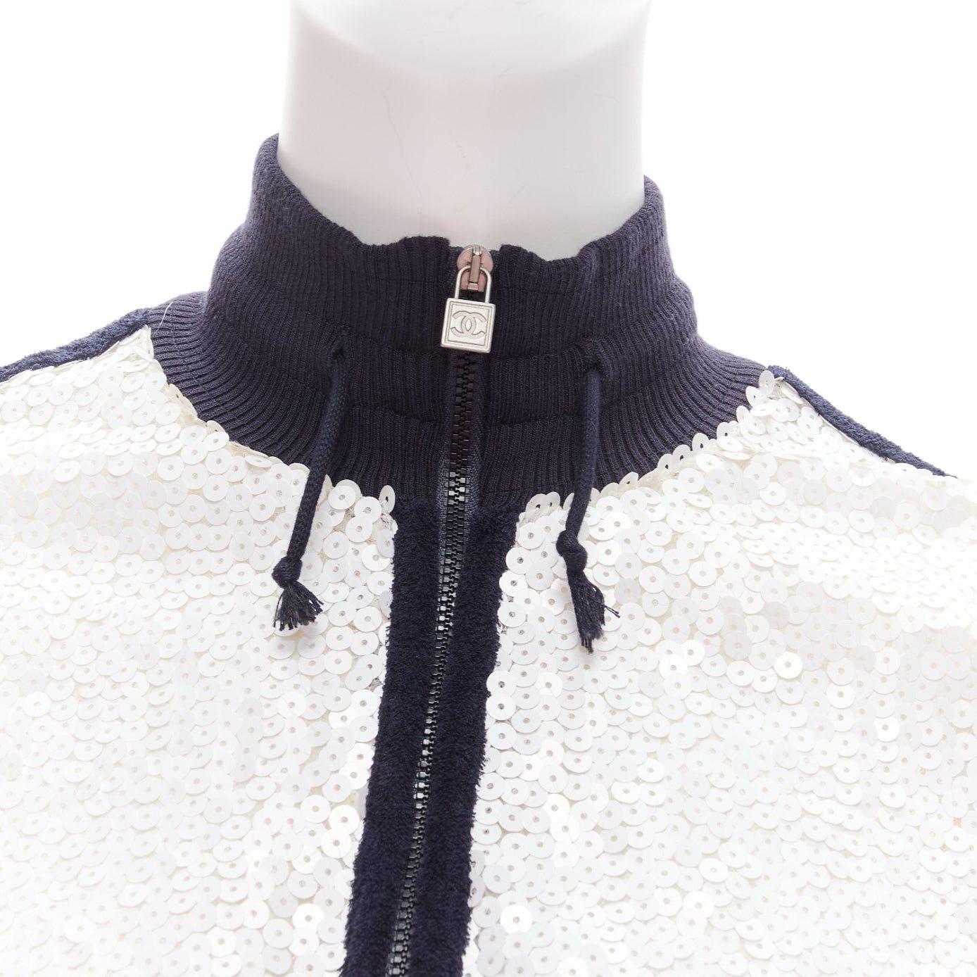 CHANEL 08C SPORTS rare veste de course avec bordure noire et sequins blancs FR38 M
Référence : NKLL/A00010
Marque : Chanel
Designer : Karl Lagerfeld
Collectional : 08C Sports
Matière : Polyester, soie
Couleur : Blanc, Noir
Motif :