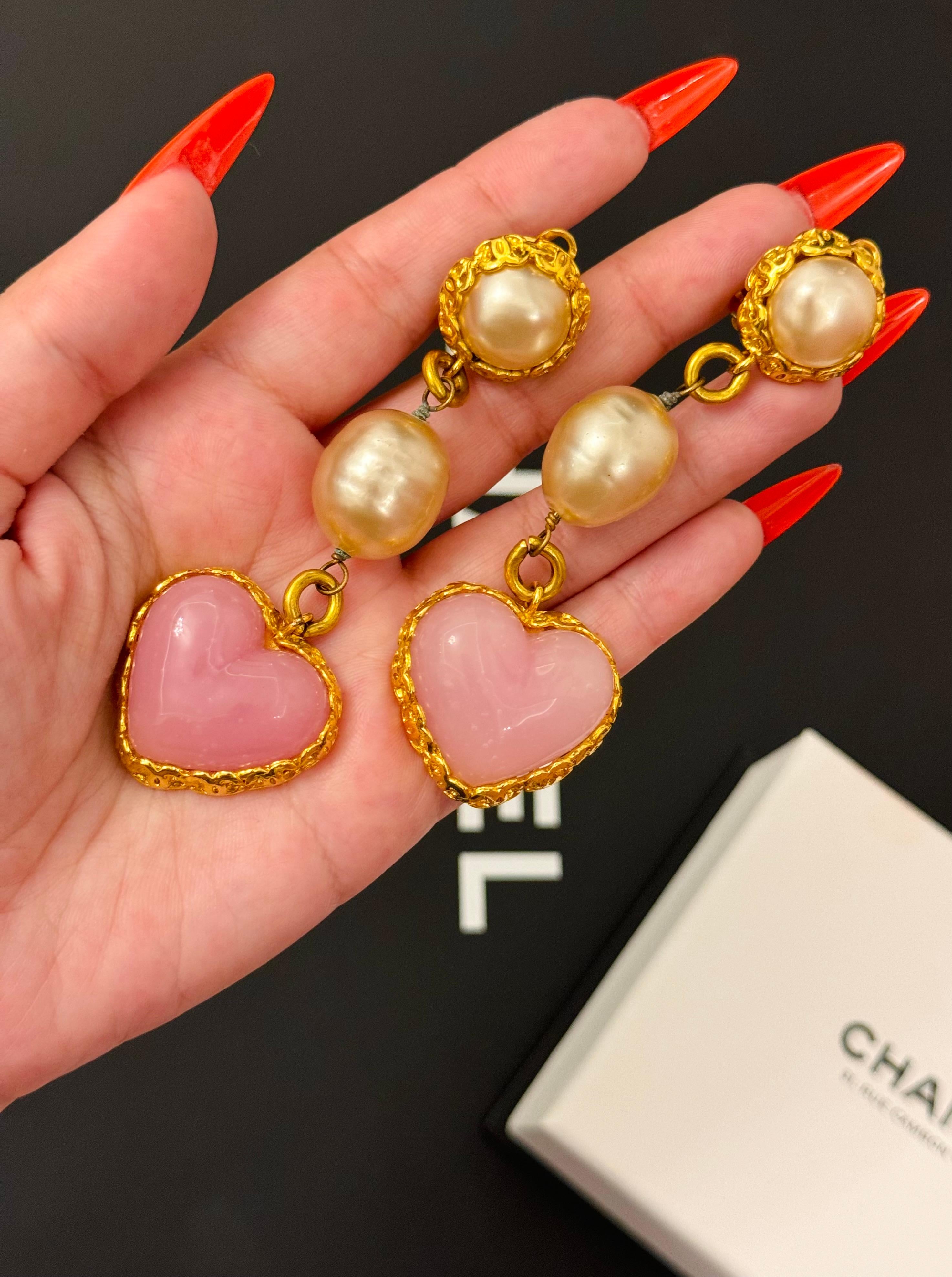 Rare Chanel 1992 (saison 28 par Victoire de Castellane) Boucles d'oreilles pendantes en forme de coeur rose et perle, plaqué or 24k, logo CC tout autour, légères rayures sur le dos de la perle comme on peut le voir sur la photo. C'est un véritable