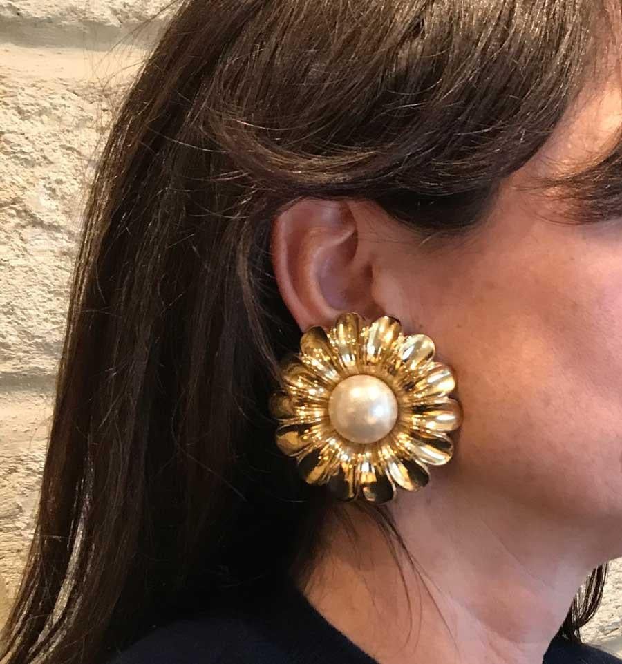 Collector and Rare CHANEL vintage flower clips. 
Exceptional pair of clip-on earrings from the 80s each representing an imposing daisy, with petals gilded with fine gold, pearl at the center.
In good condition. We note a sparkle on each of the pear