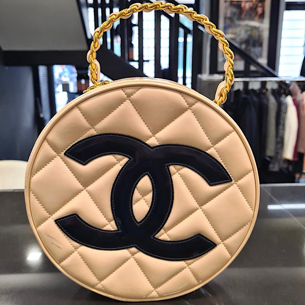 Rare, Collector, superbe sac à main rond CHANEL en cuir beige et noir.
Une pièce magnifique que les collectionneurs s'arrachent. Ce sac de collection CHANEL date des années 1994-1996.
Le bijou est en métal doré et il a une double fermeture éclair.