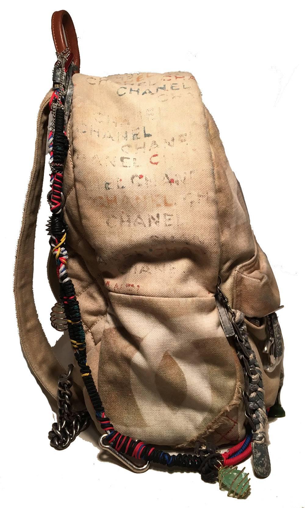 AMAZING LIMITED EDITION Chanel large canvas graffiti art school backpack in very good condition. Beige canvas toile exterior featuring hand painted graffiti and stencil designs throughout. Attached sea glass and silver wire wrapped charm braided